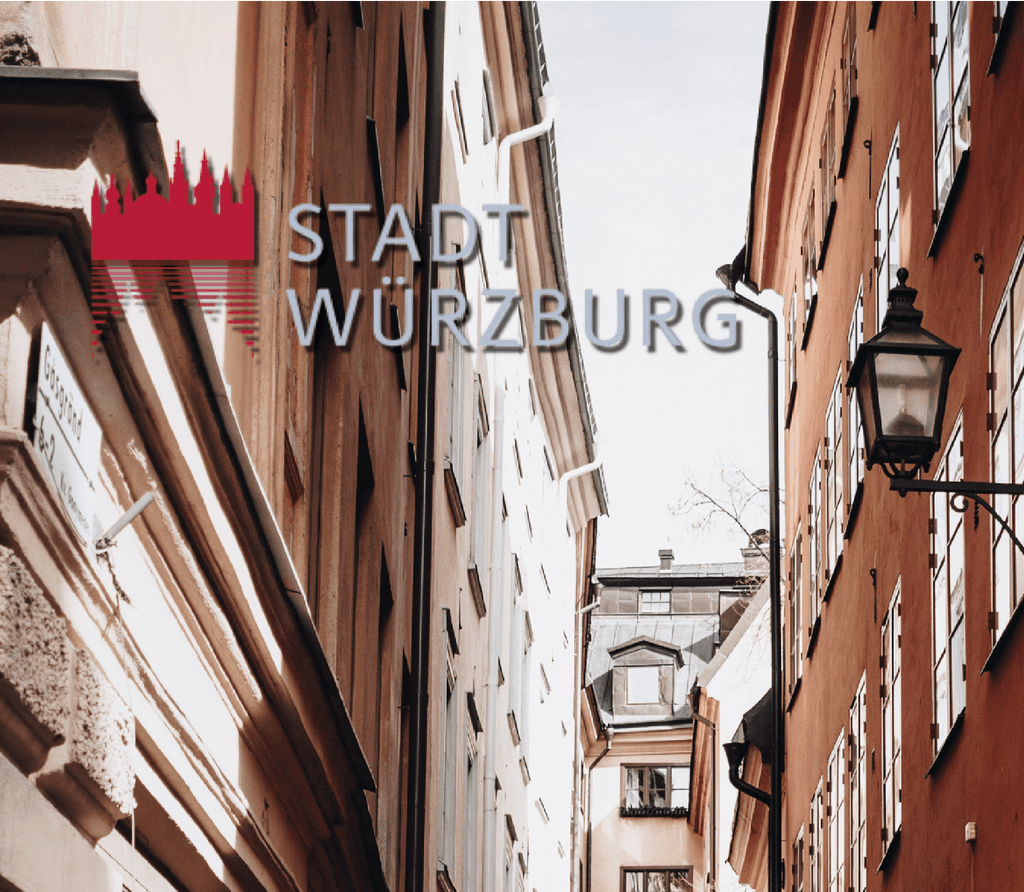 Eine Gasse in einer Altstadt an einem schönen Sommertag darauf befindet sich das Logo der Stadt Würzburg