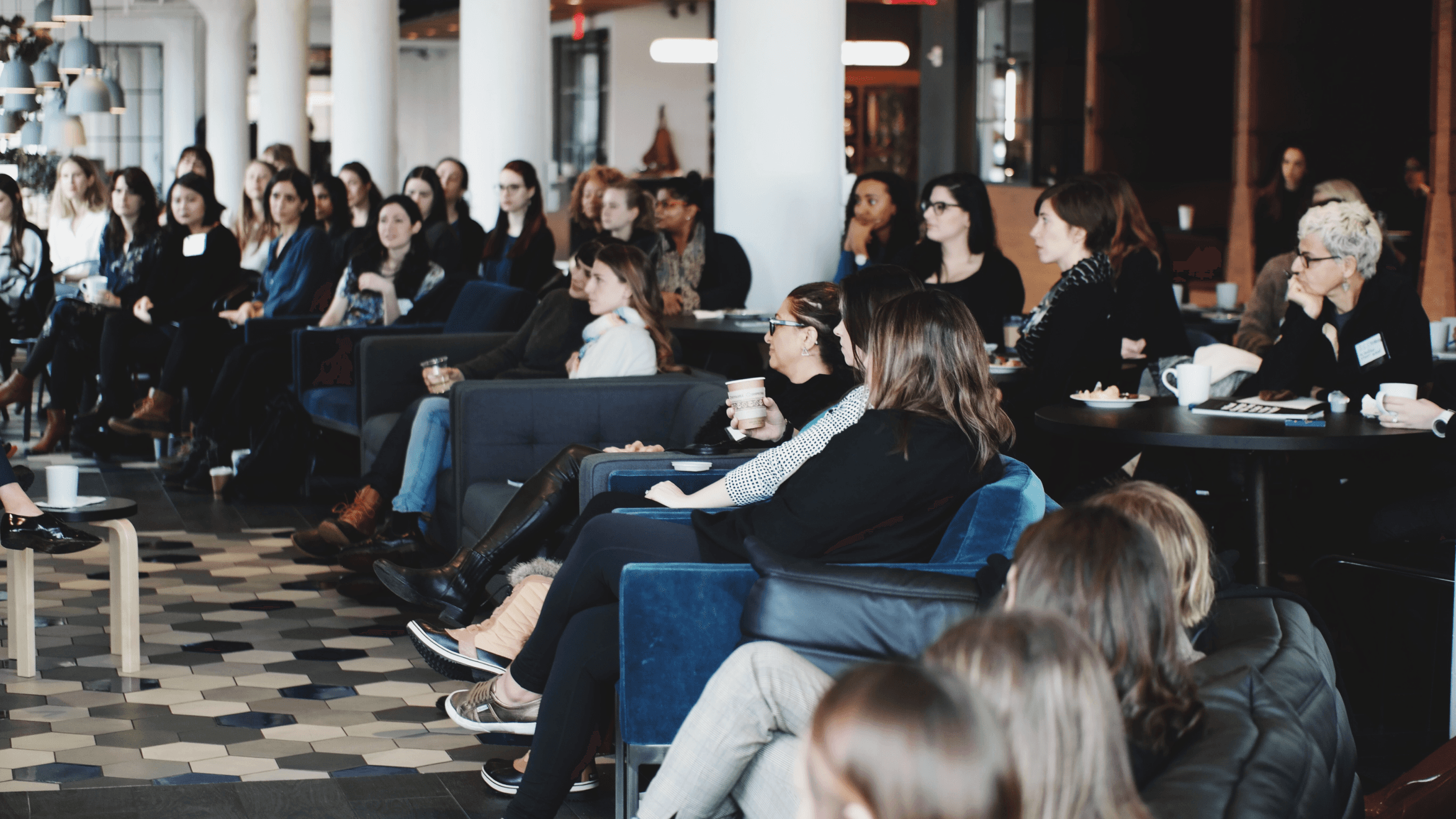 Three individuals pose for a photo at a stylish event, with a modern interior in the background.