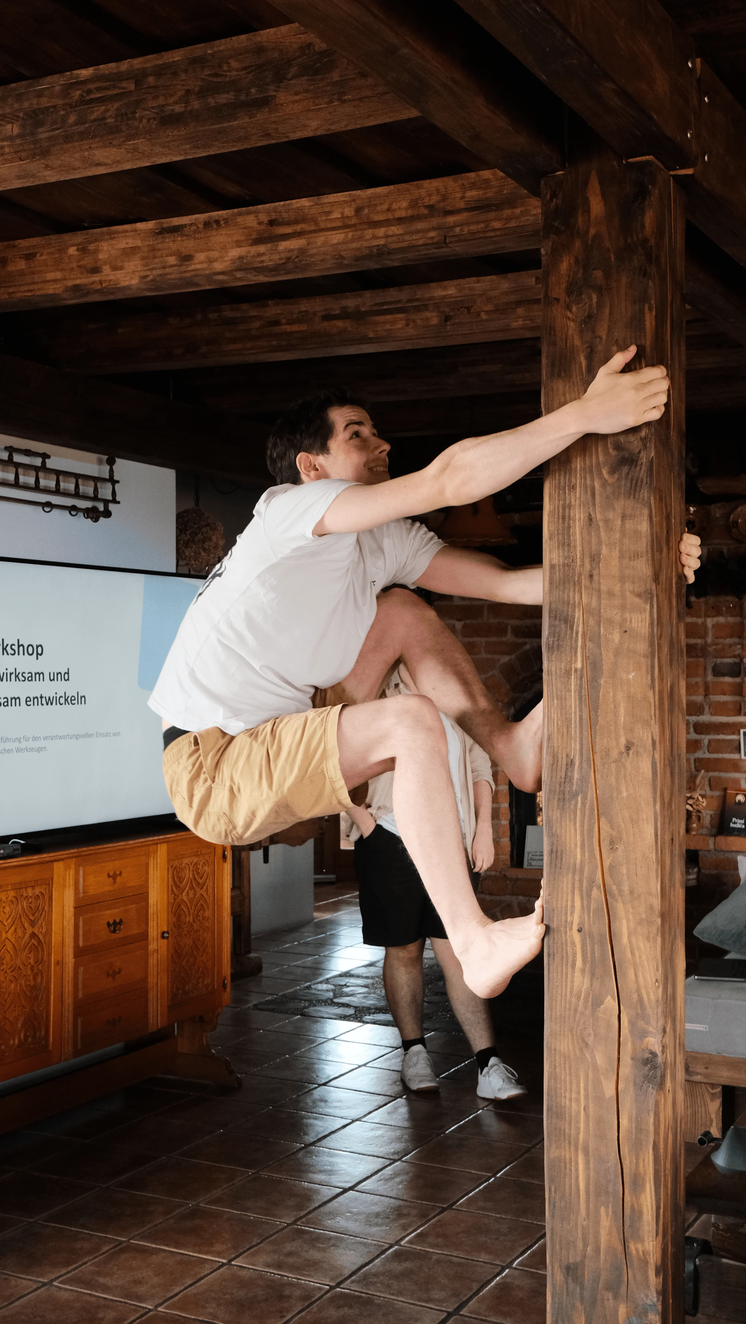 Person klettert auf eine Holzpfosten