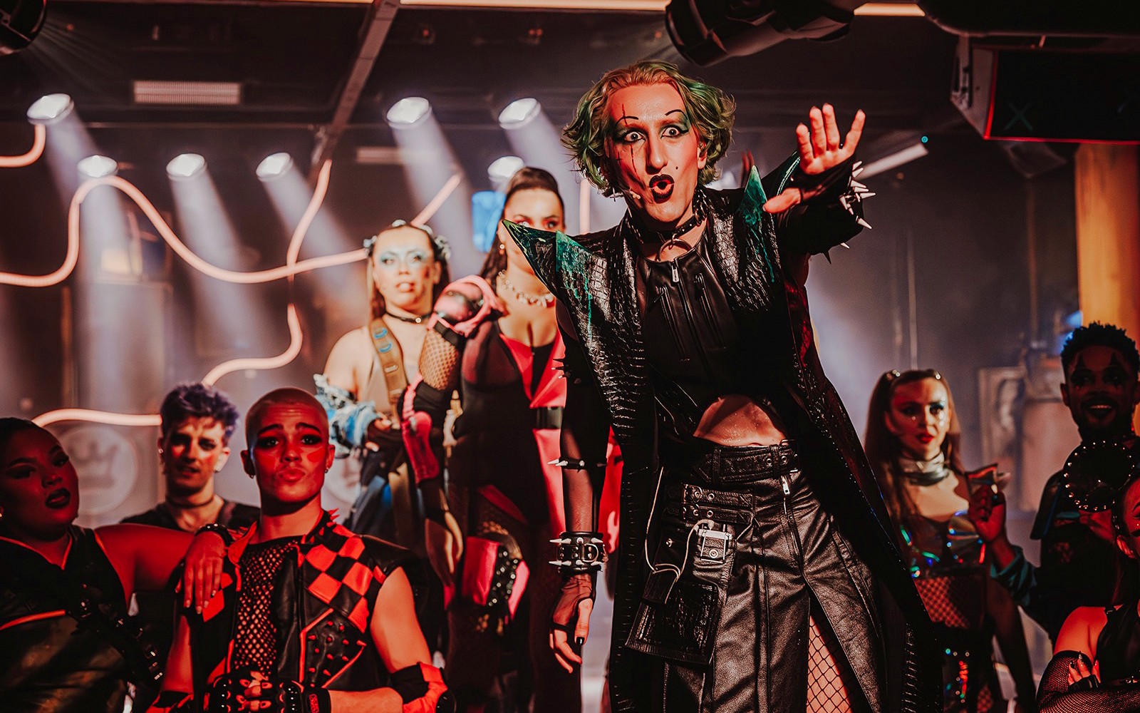 Performer on stage at "Oscar at the Crown" show with dramatic lighting and costumes.