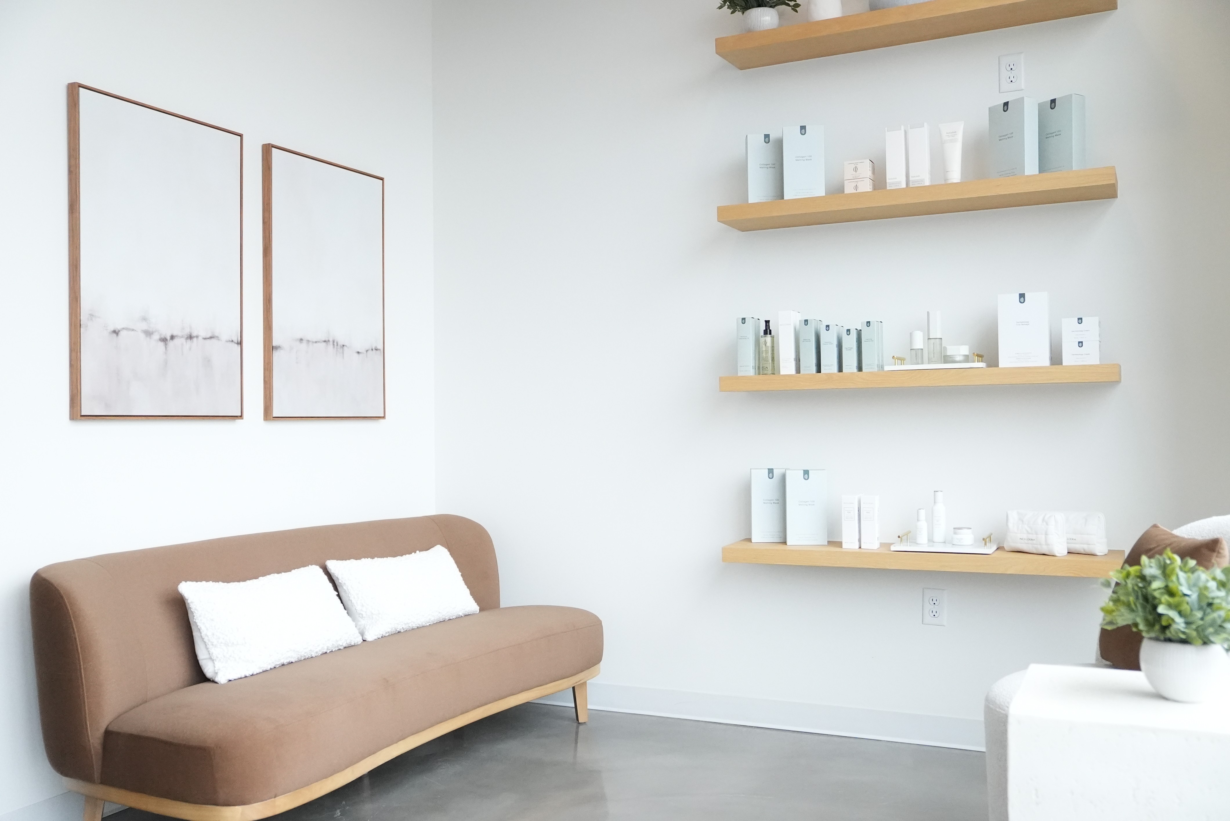 A serene and elegant spa space with wooden reclining chairs and white cushions. Golden sunlight filters through a cascading water feature, creating a peaceful atmosphere. Tropical plants and candles add to the relaxing ambiance.