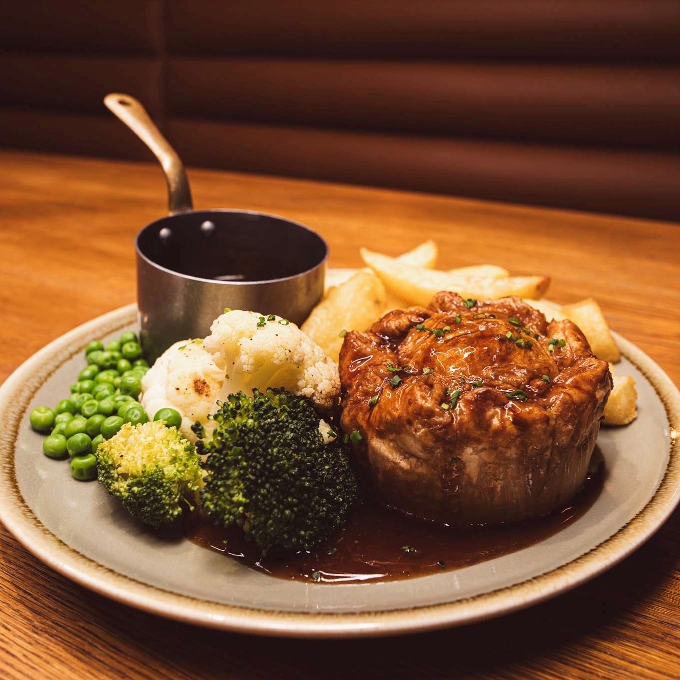 A plate on a table with pie peas mashed potatoes