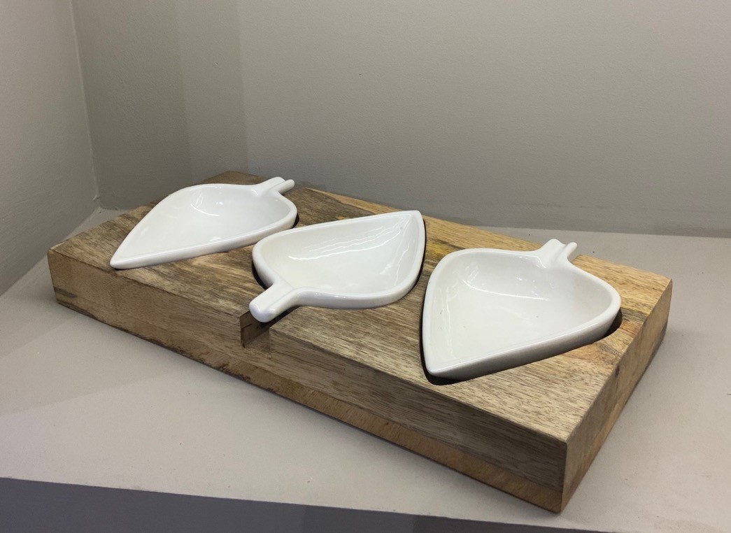 White leaf shaped ceramic snack bowls on wooden tray
