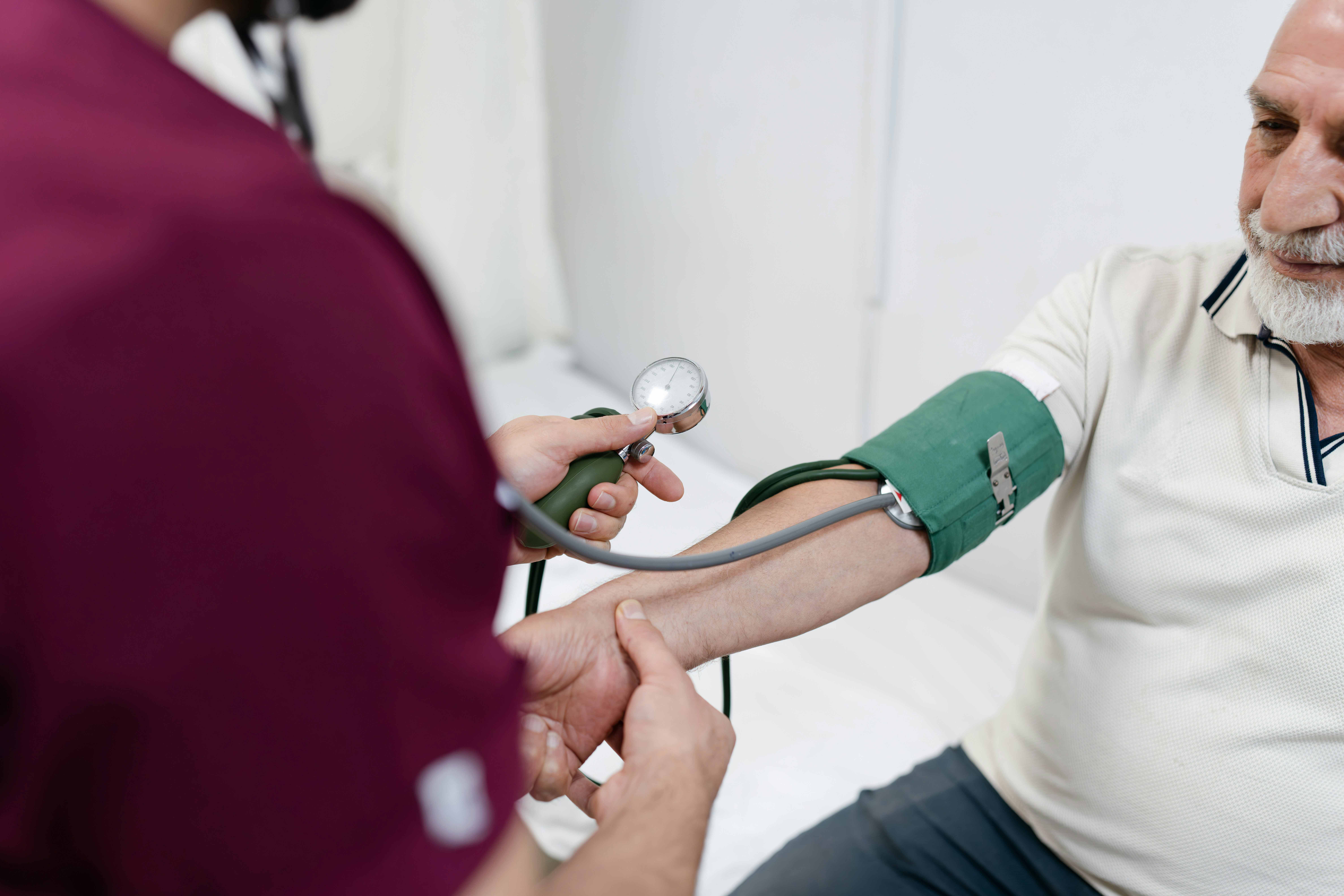 Blutdruckmessung eines älteren Herren in der Praxis