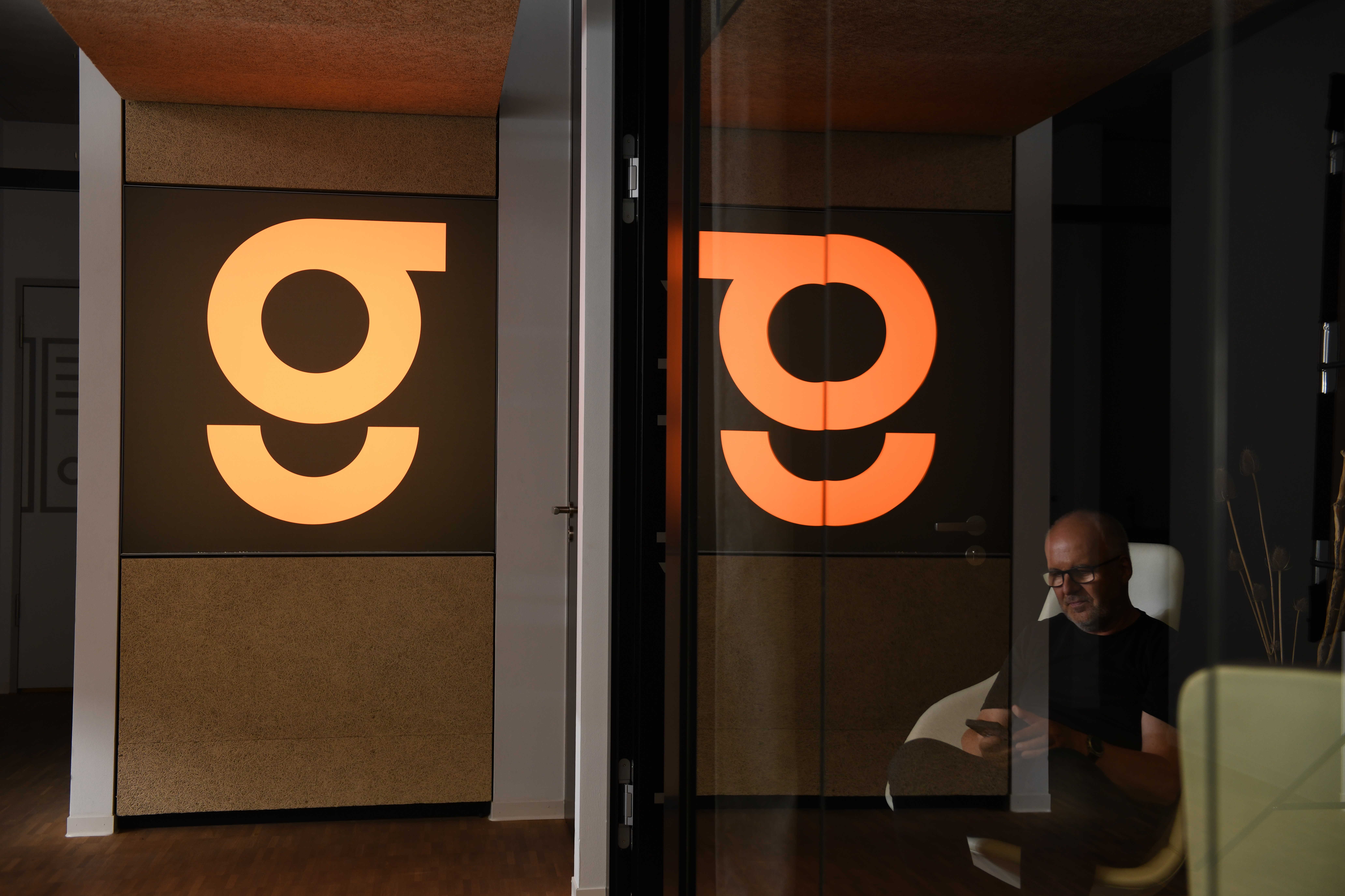 Frau steht mit Blumen in der Hand an Wand