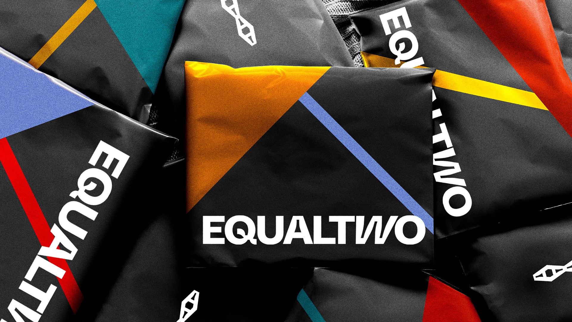 Several black bags with diagonal stripes in teal, yellow, orange, and red are arranged closely together. The word “EQUALVO” is printed in white on each bag.