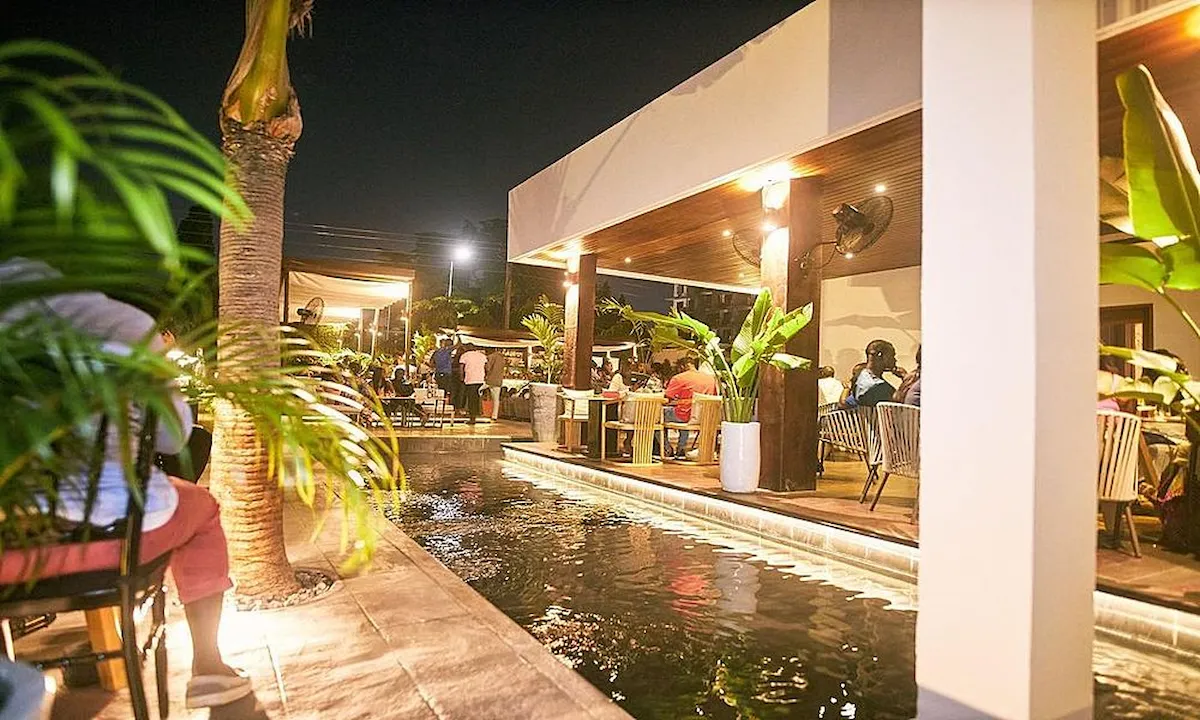 Poolside restaurant with palm trees and outdoor seating in Accra, Ghana.