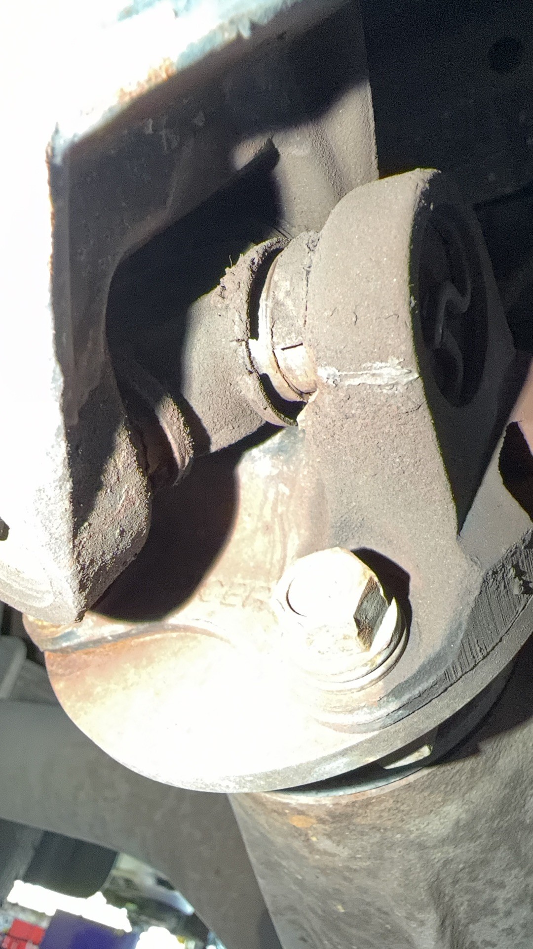 Close-up of the worn U-joint and damaged flange on the aftermarket driveshaft