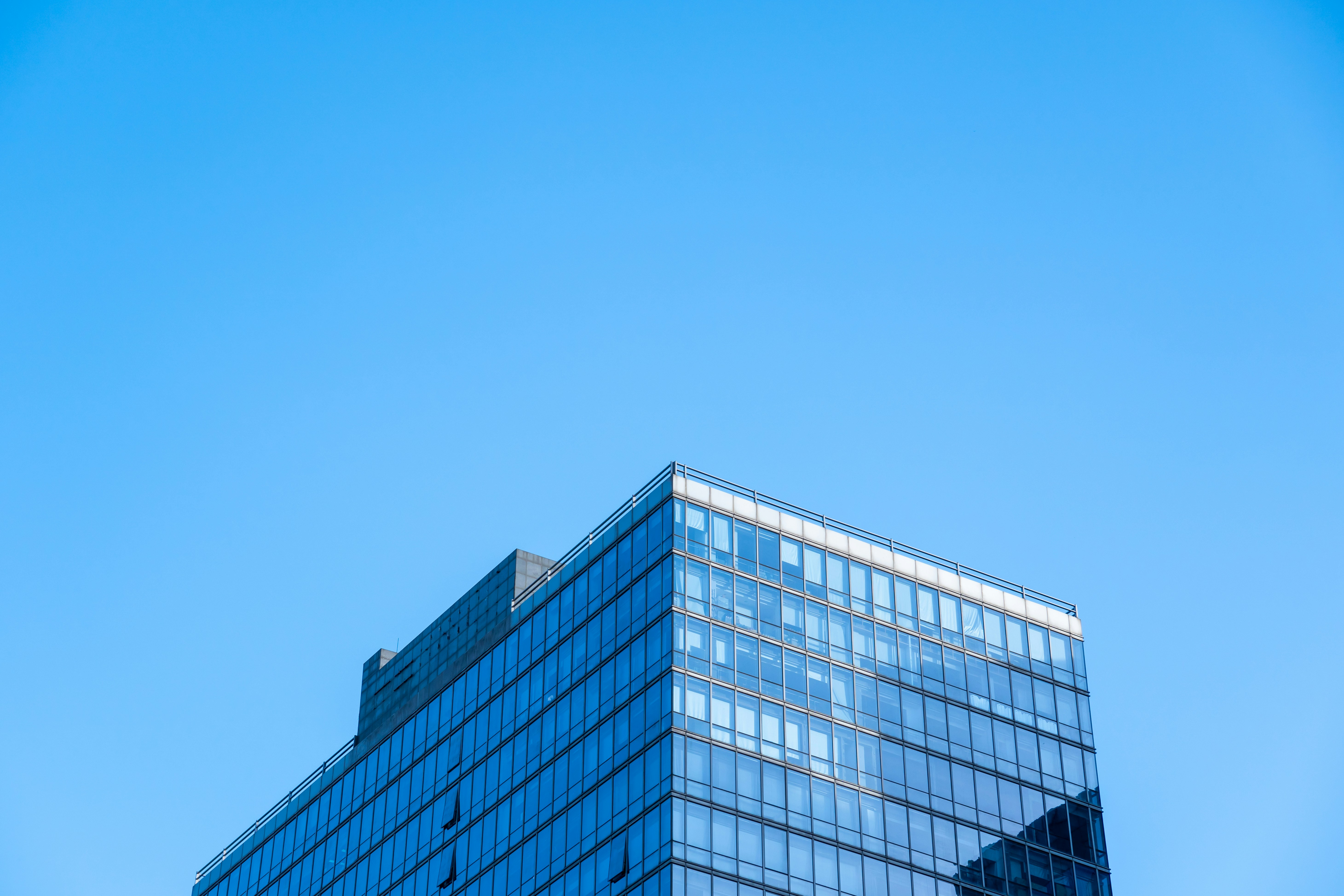 a very tall glass building with a blue sky in the background