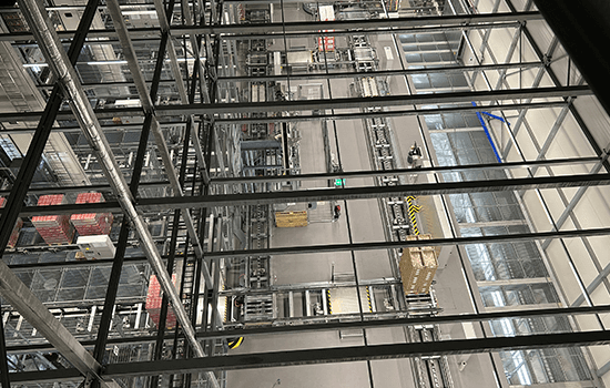 Four diverse professionals collaboratively working on a laptop, with one person pointing at the screen while others observe.