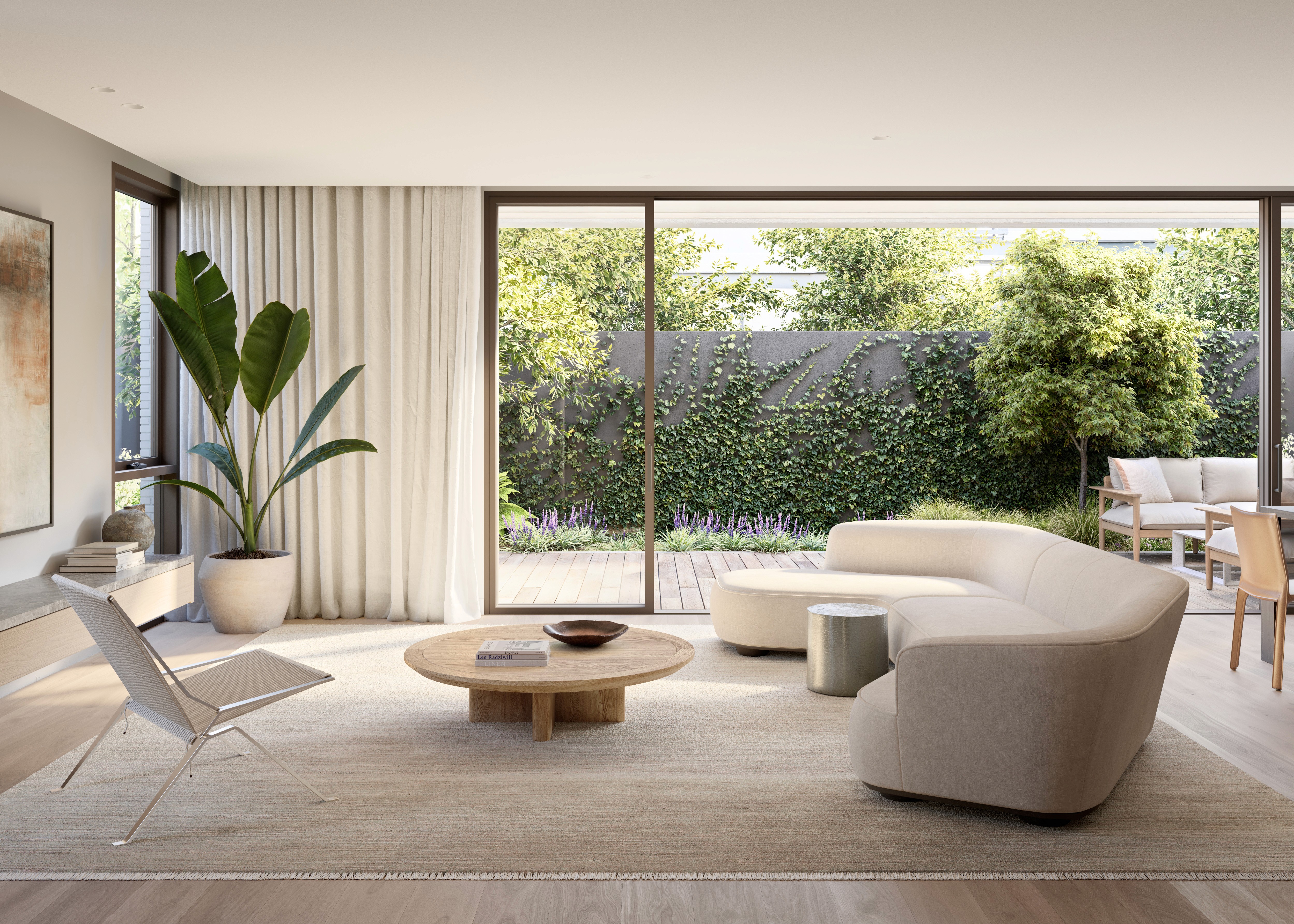 Modern living room with large windows, stylish beige furniture, indoor plant, and garden view.