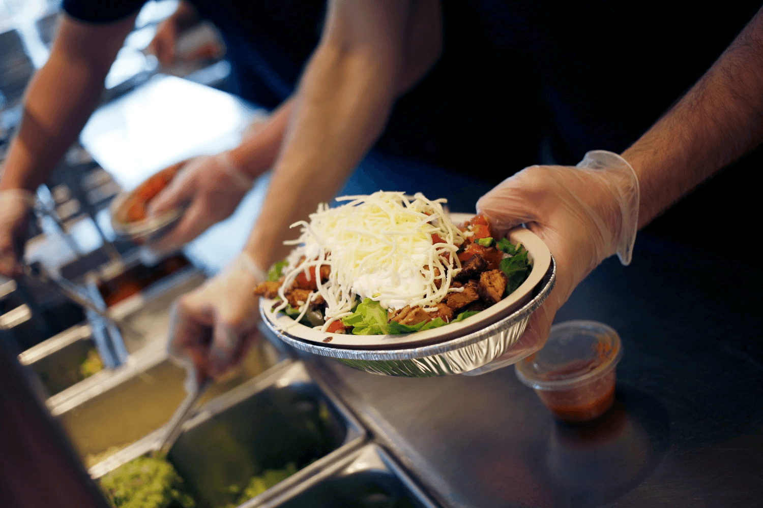 An image of a Chipotle crew member fulfilling an order.