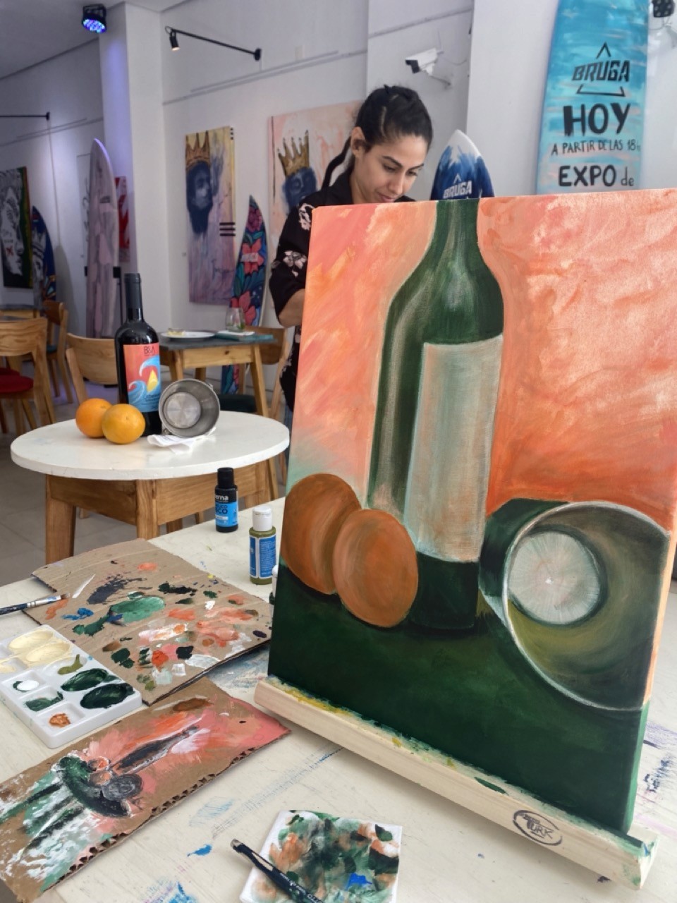 A view from an airplane window shows the aircraft's wing with a golden hue reflecting the setting sun, against a serene backdrop of fluffy clouds and a clear sky.