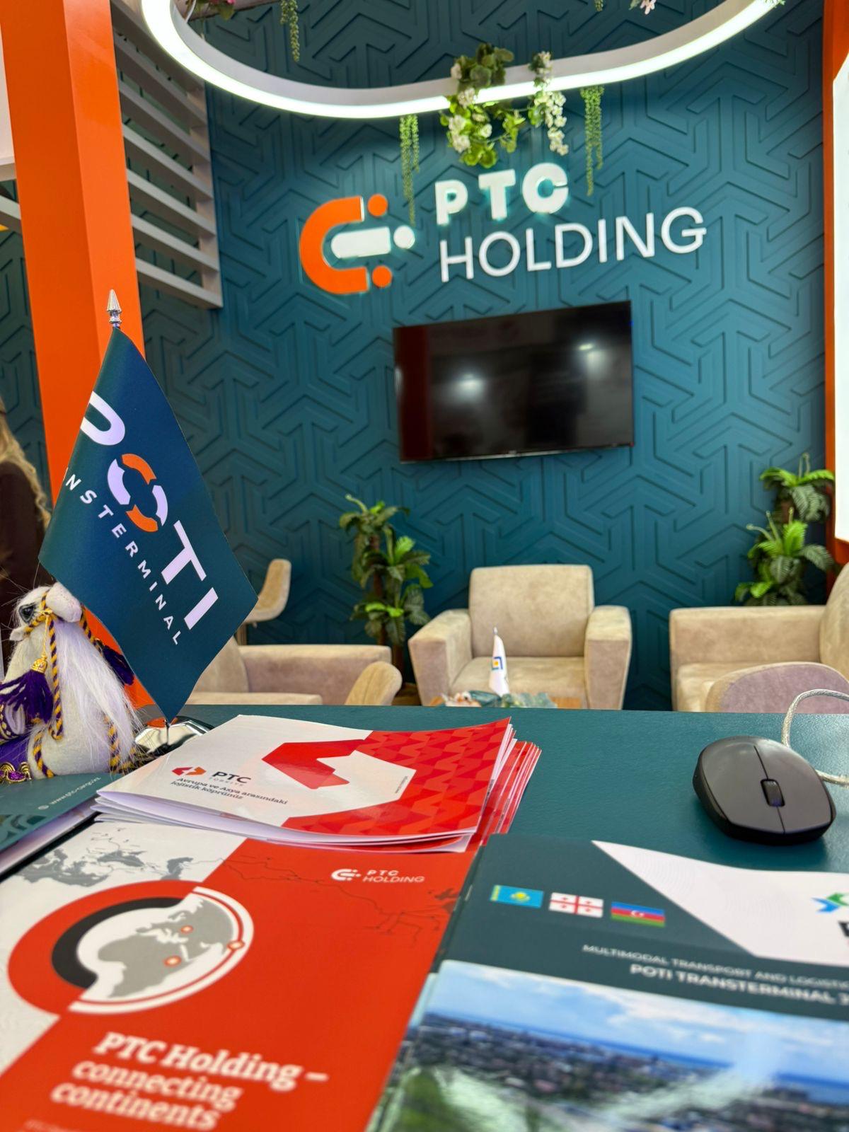Reception counter and open meeting area at the PTC Holding stand, designed for networking and client接待.
