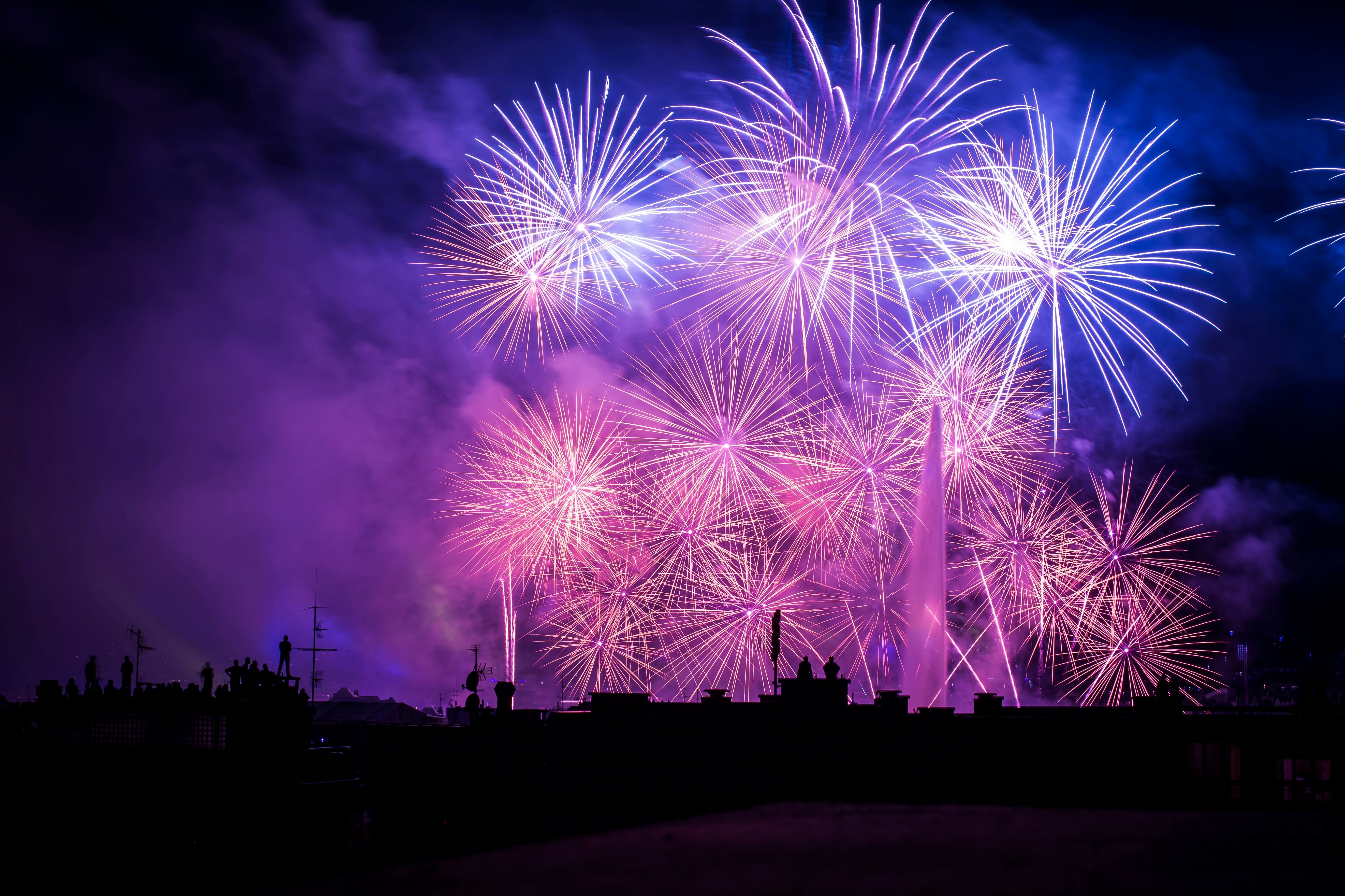 man staring at fireworks in the night sky
