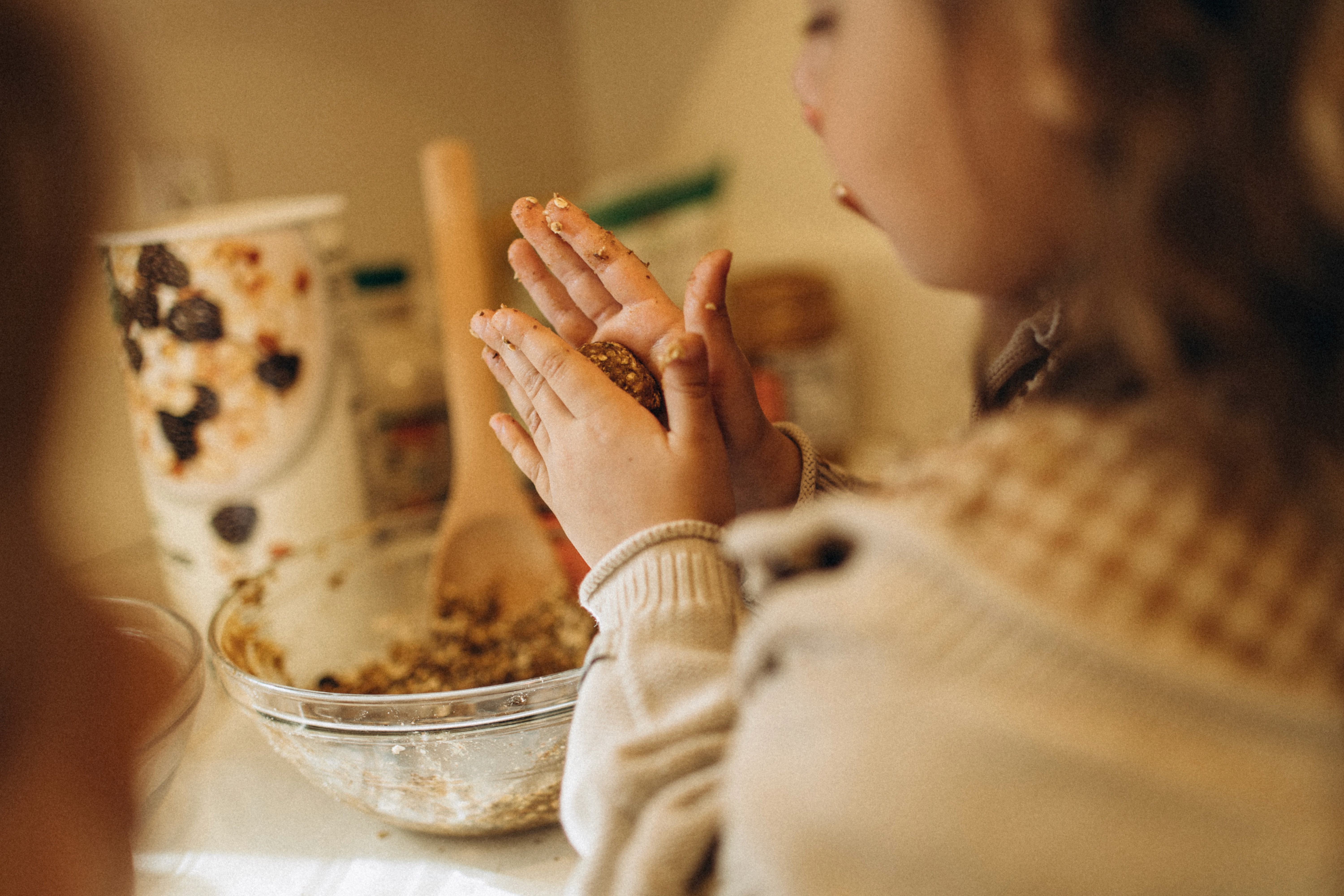 Child baking in the kitchen during a warm, everyday family moment.
