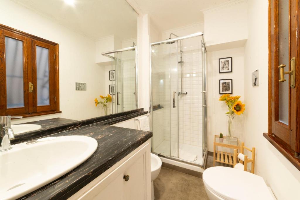 Beige upholstered bed with patterned pillows and ottomans