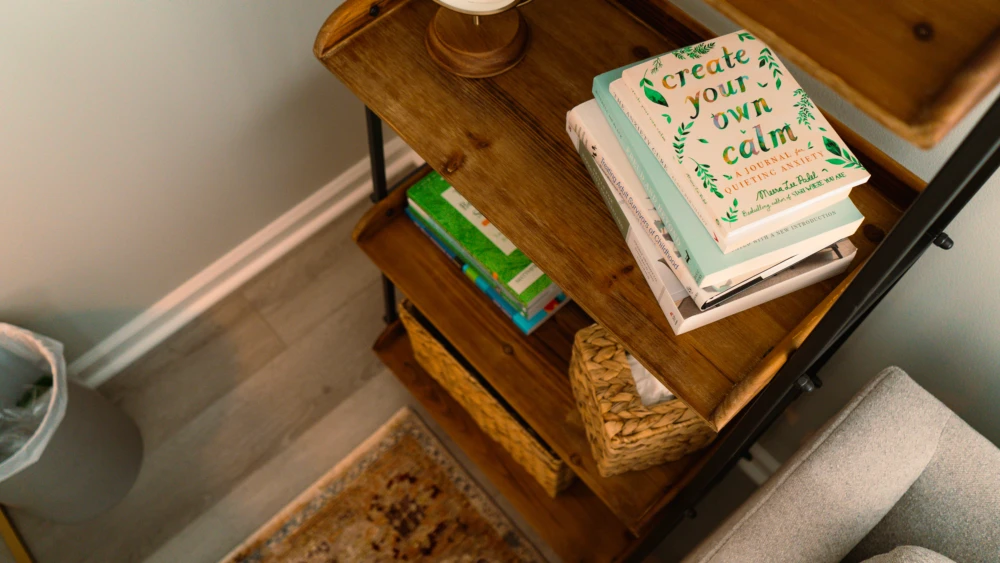 Wooden shelving unit with books, woven basket, and small storage containers.