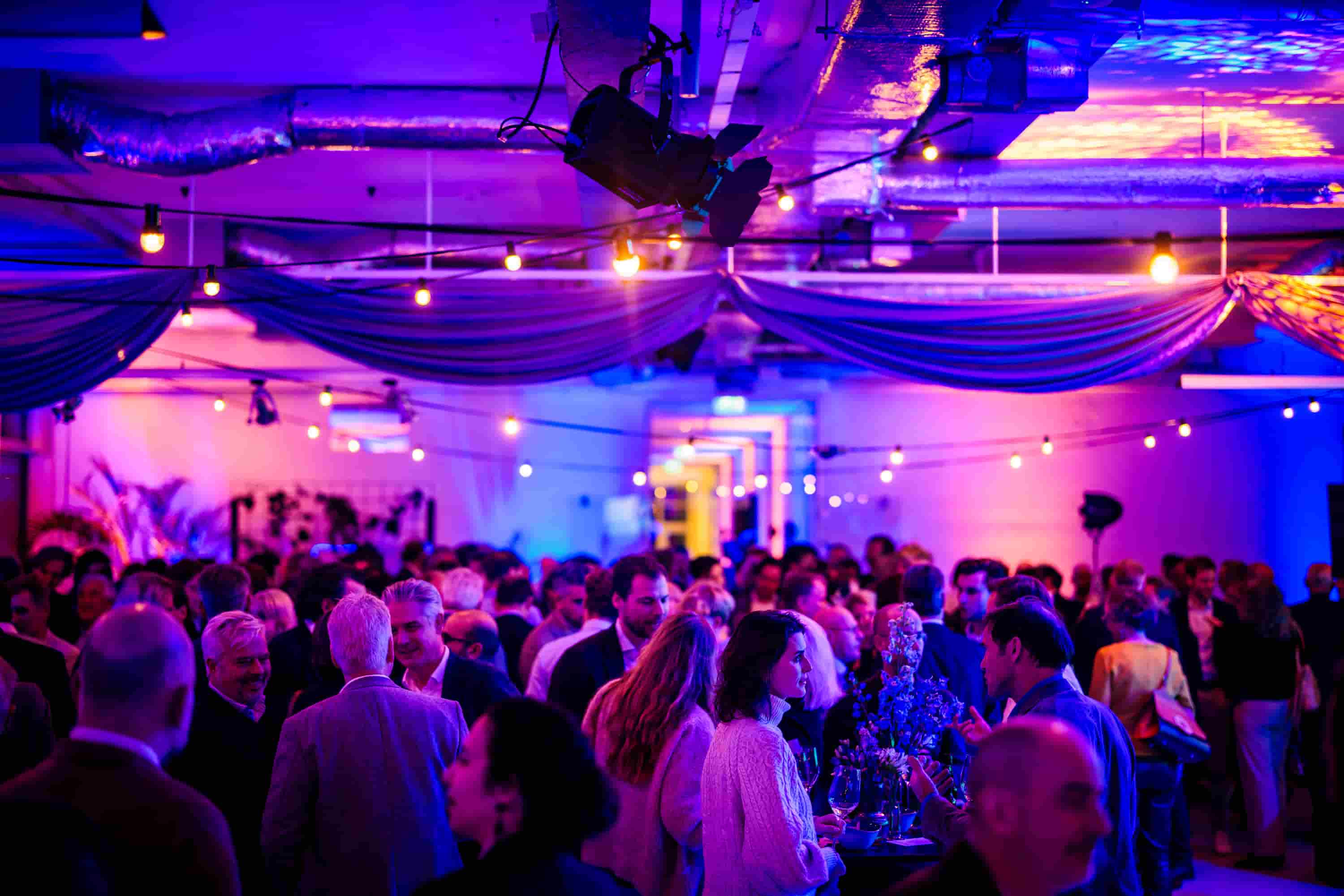 Sfeervolle nieuwjaarsreceptie met live entertainment en kleurrichte verlichting in Amsterdam
