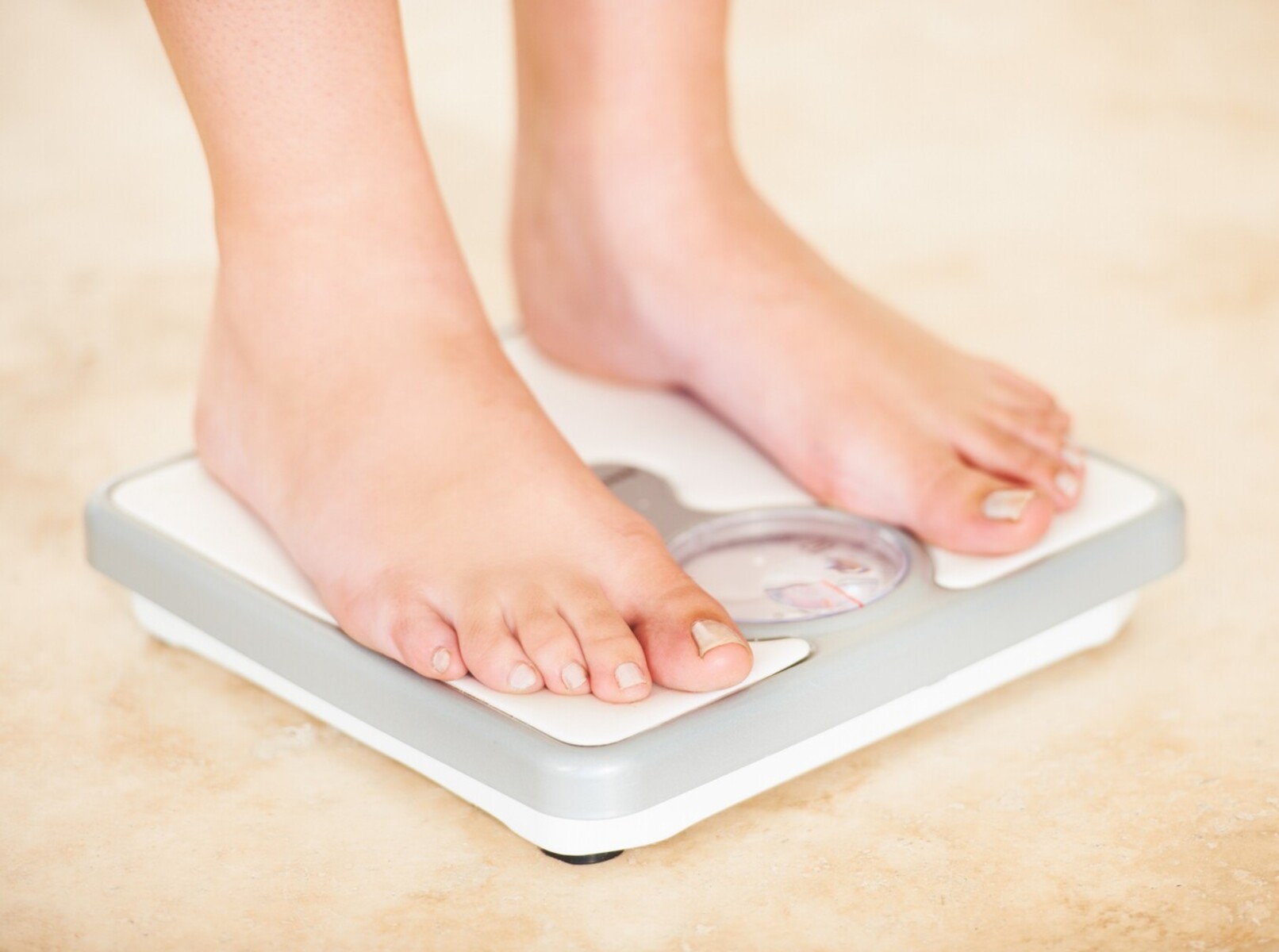 person standing on a scale to check their results from using vibration machines for weight loss