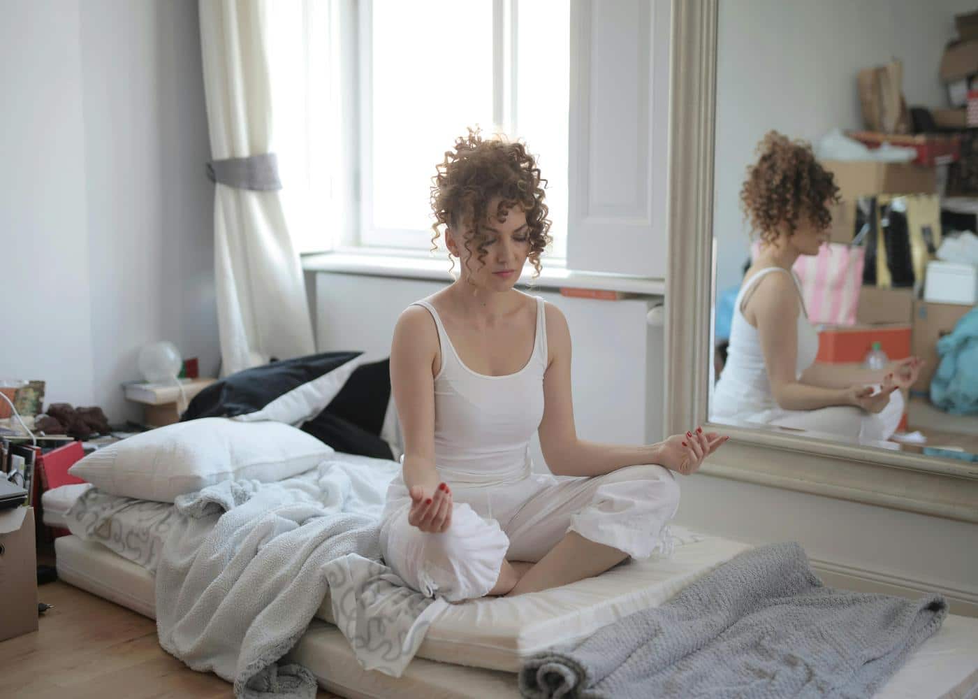 Guided five-minute meditation - Woman meditating on an unmade bed