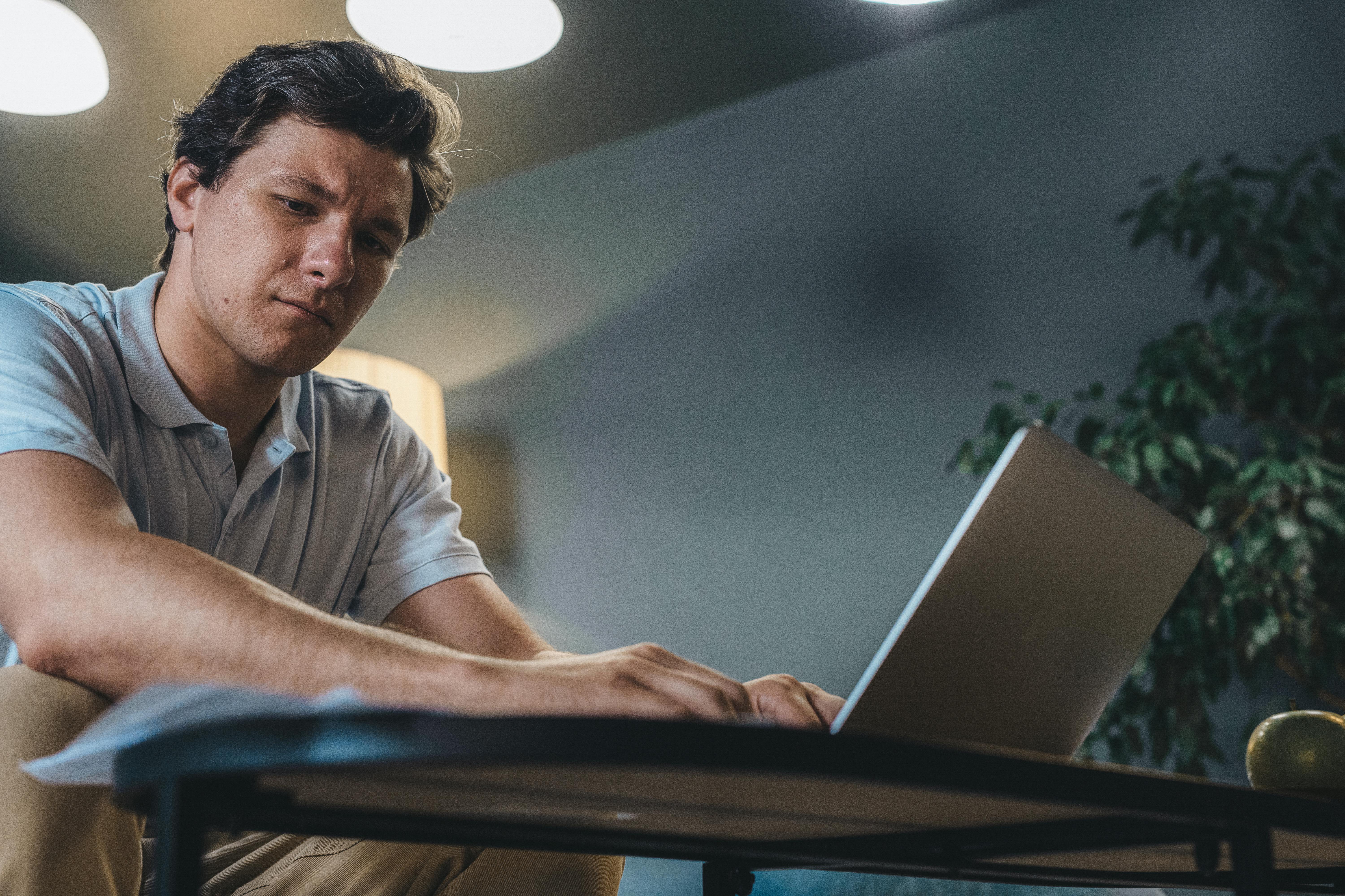 Man in a professional interview setting with a laptop, confidently answering questions and showcasing his unique identity.