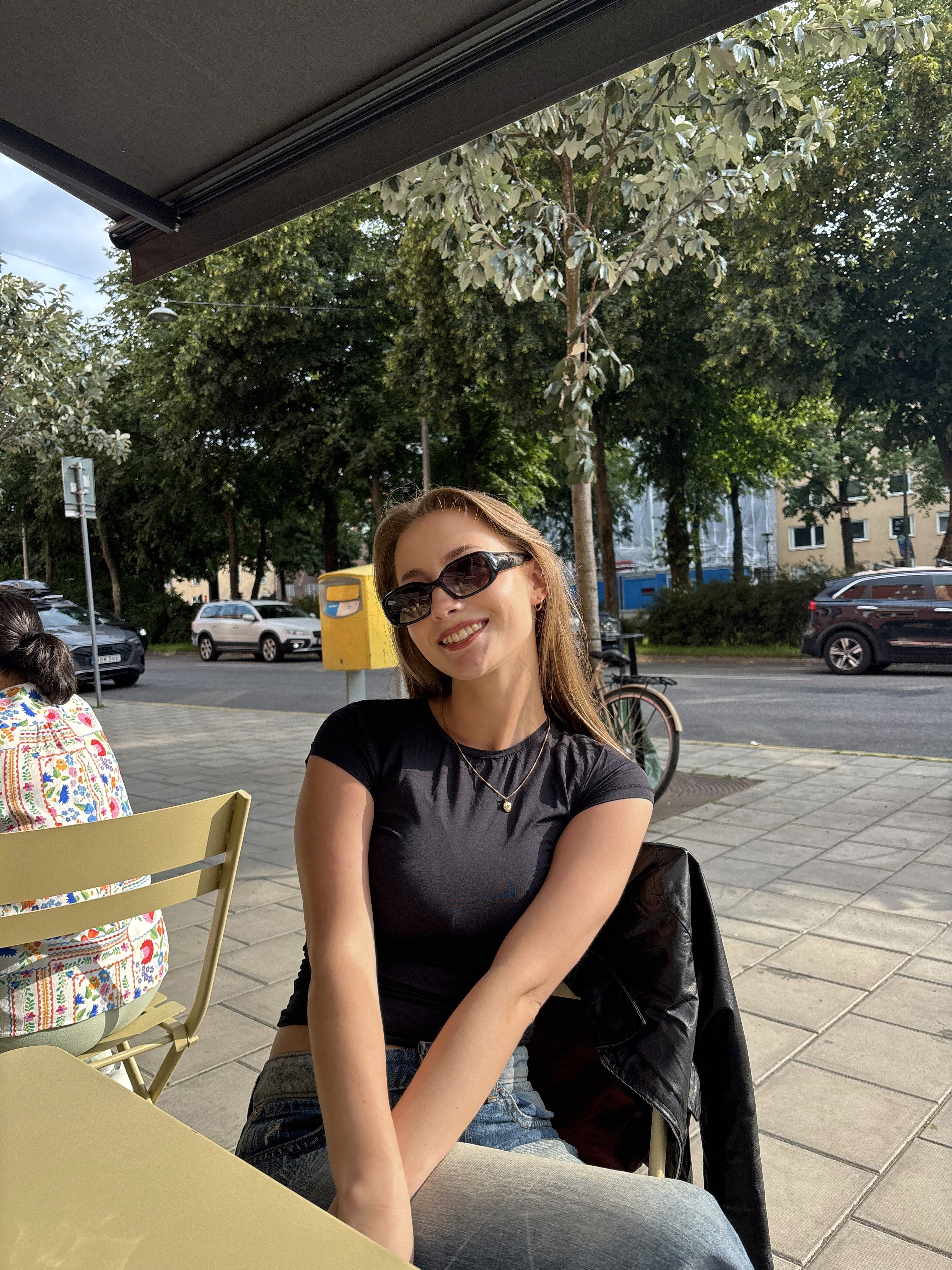 Close-up of a yellow tennis ball sitting on a green court, positioned near the white center line.