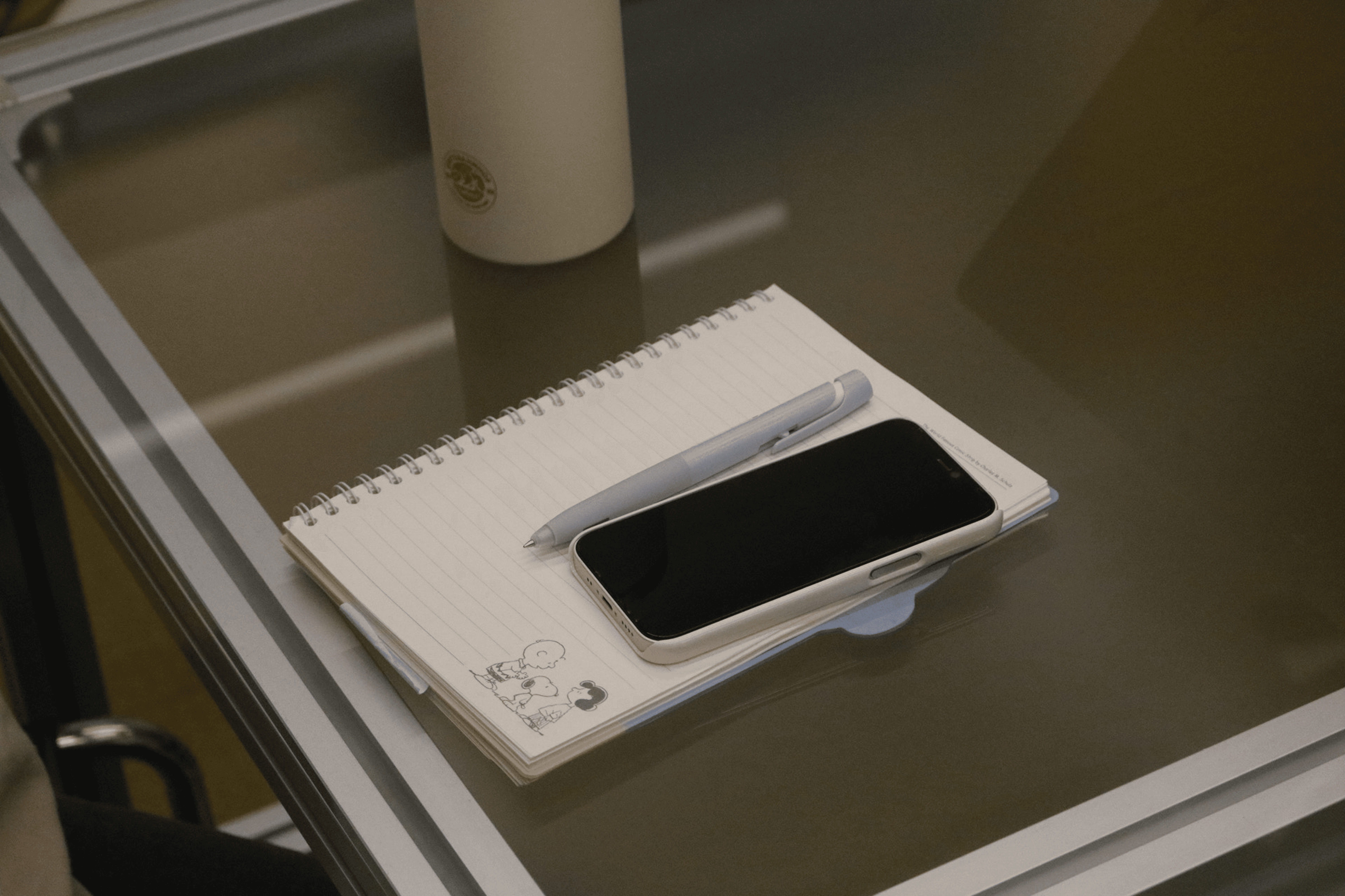 미팅을 위한 필기구와 핸드폰이 놓인 테이블 이미지