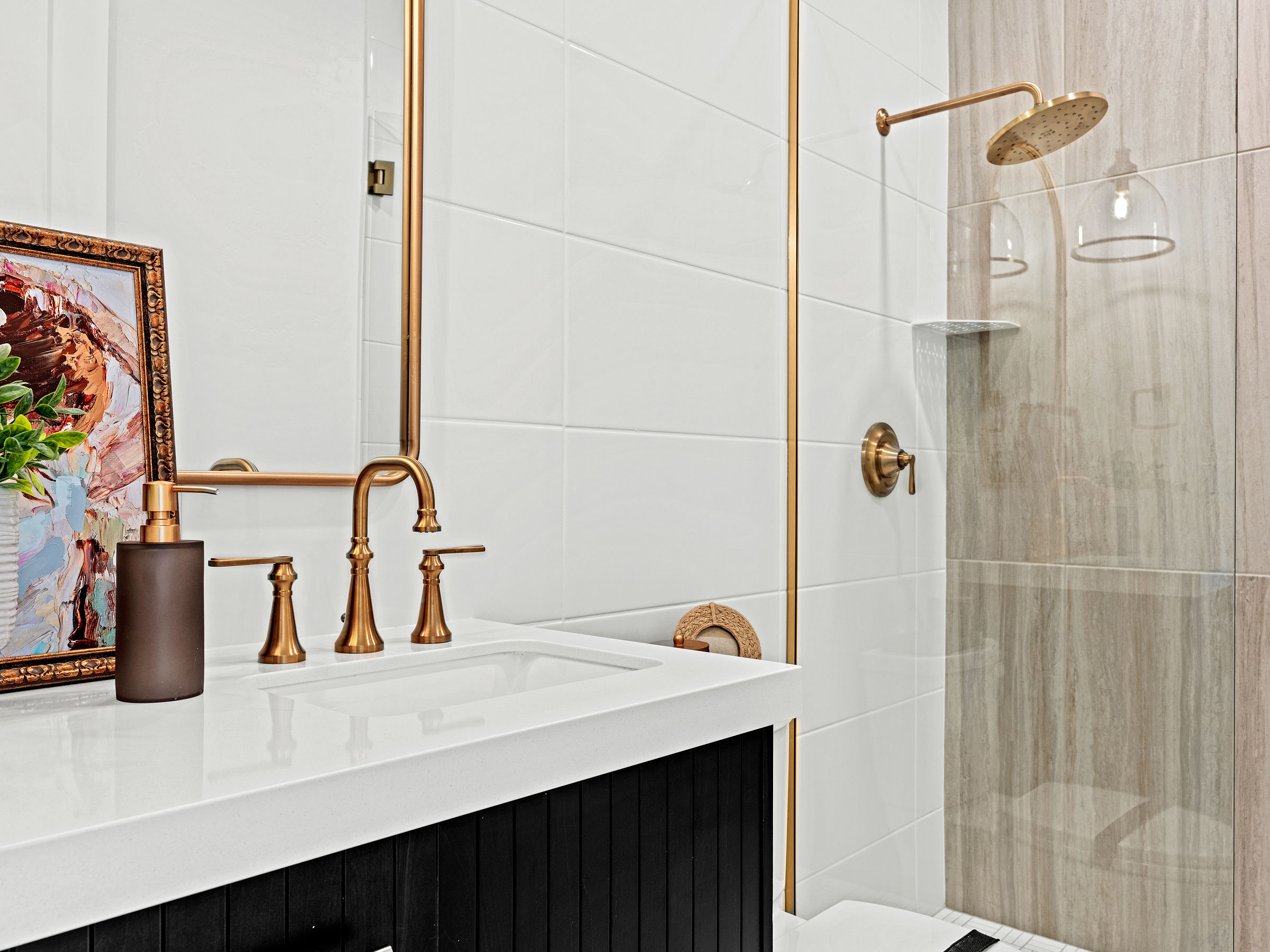 Bathroom in a custom home with brushed gold faucet and showerhead.
