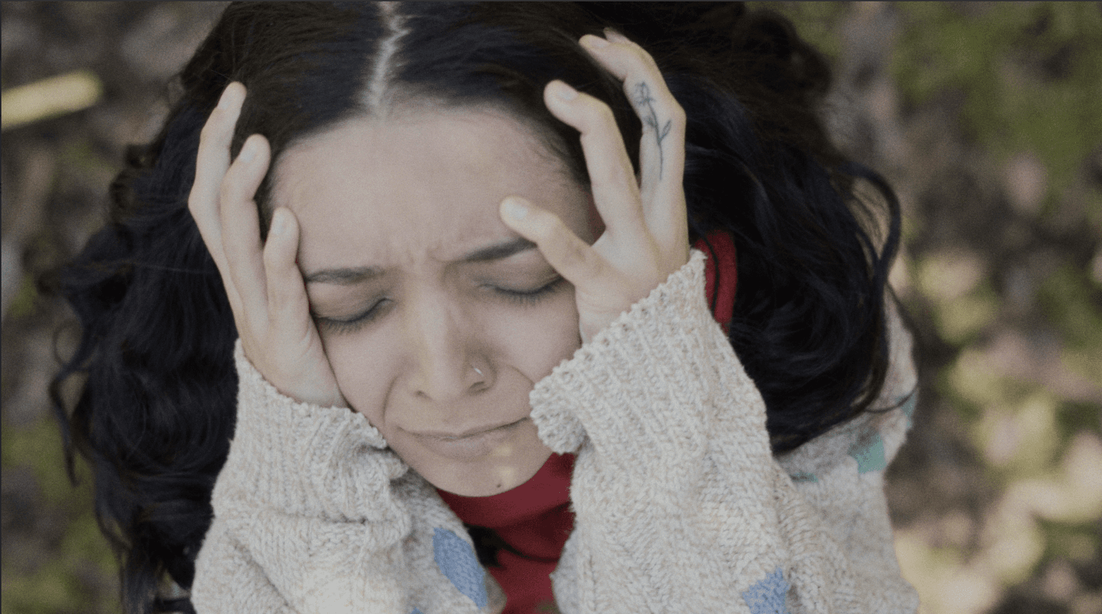View of the French countryside through a stone villa’s open living room, with sofas and trees framing the scene