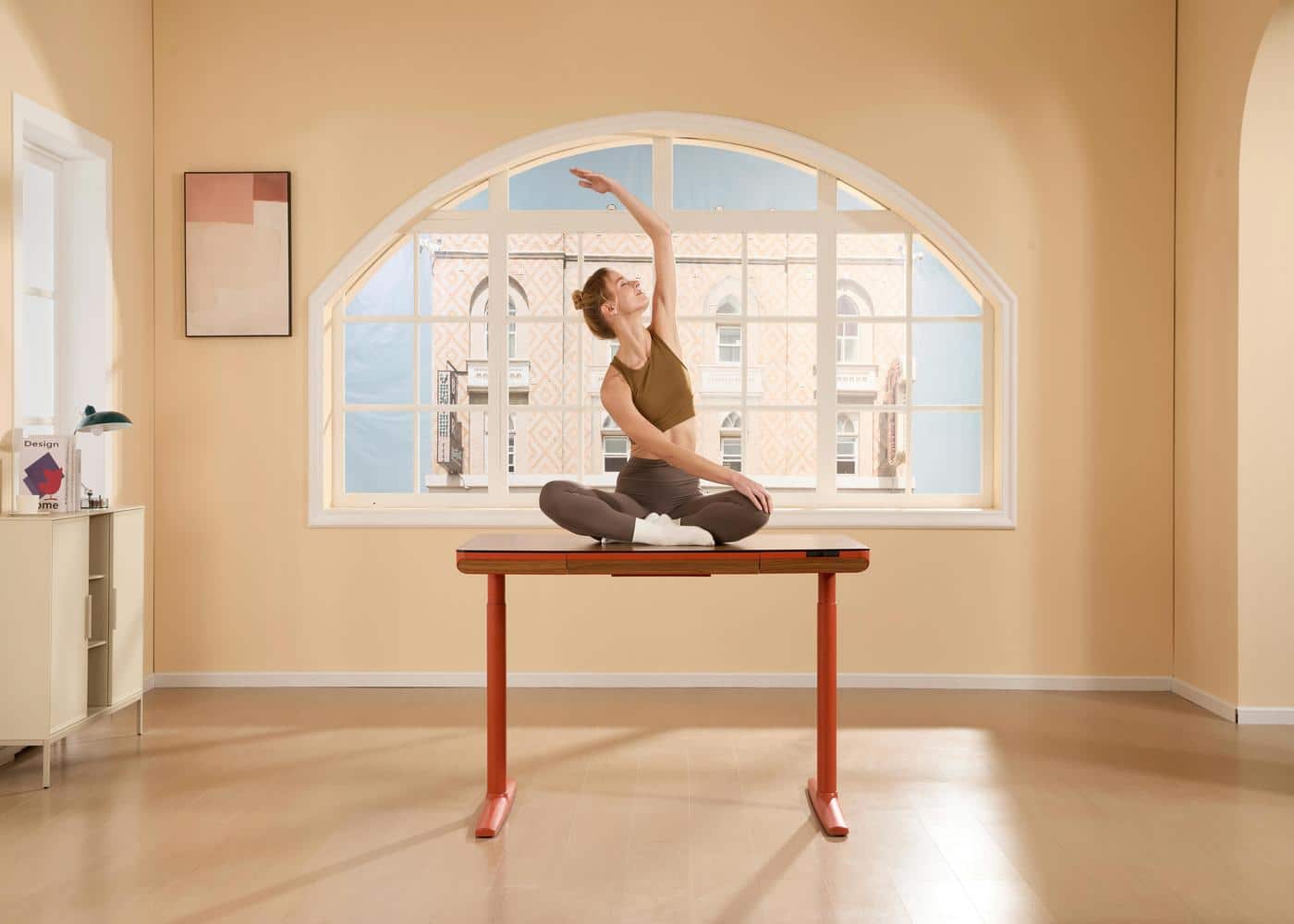 Woman stretching in a yoga pose on top of a desk practicing desk exercises for office workers