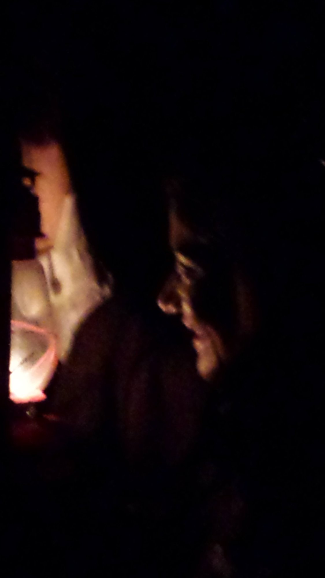 Rosto de mulher iluminado por uma lamparina em cena noturna, making of com a atriz Janaina Tardim