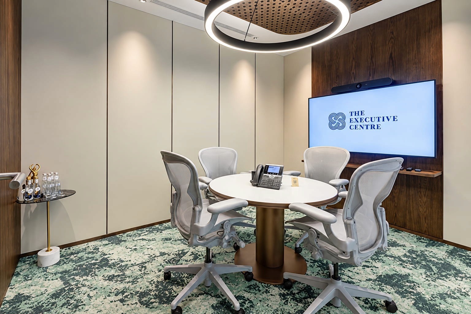 The Executive Centre meeting room in Riyadh with a round table, four office chairs, video display and modern interior