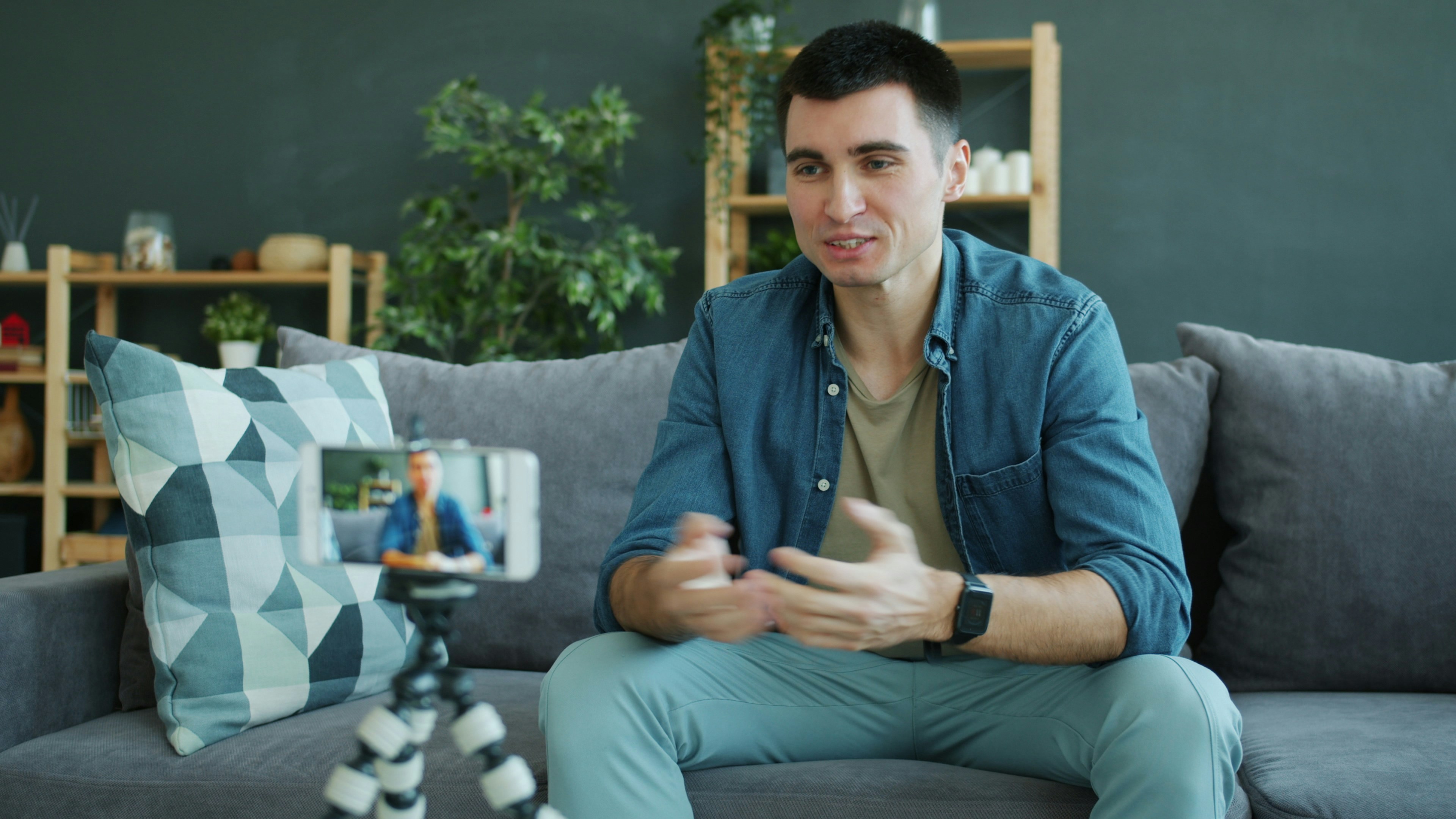 Man talking to a smartphone camera on a tripod.