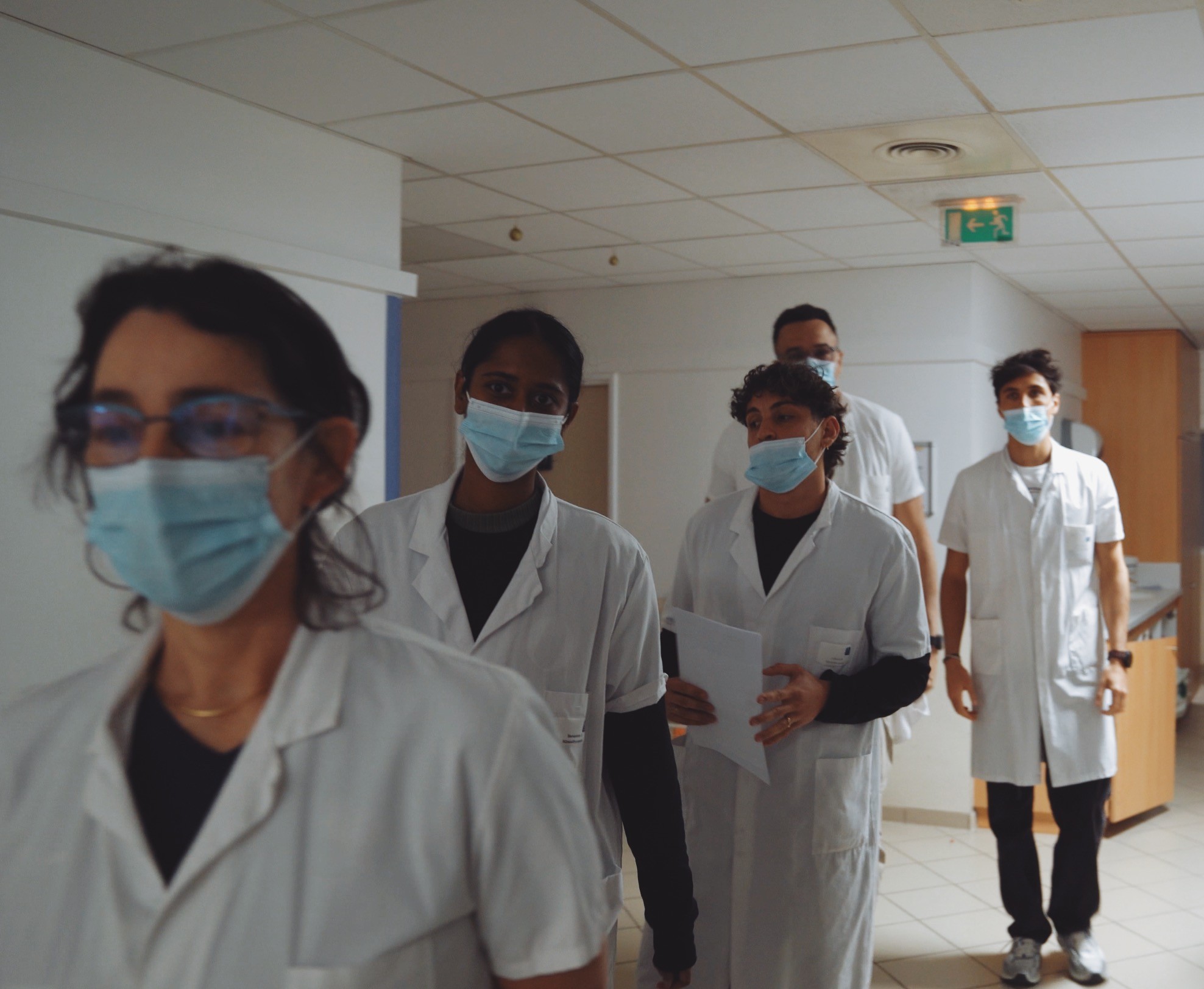 Kinésithérapeutes masqués en déplacement dans les couloirs d’un centre médical