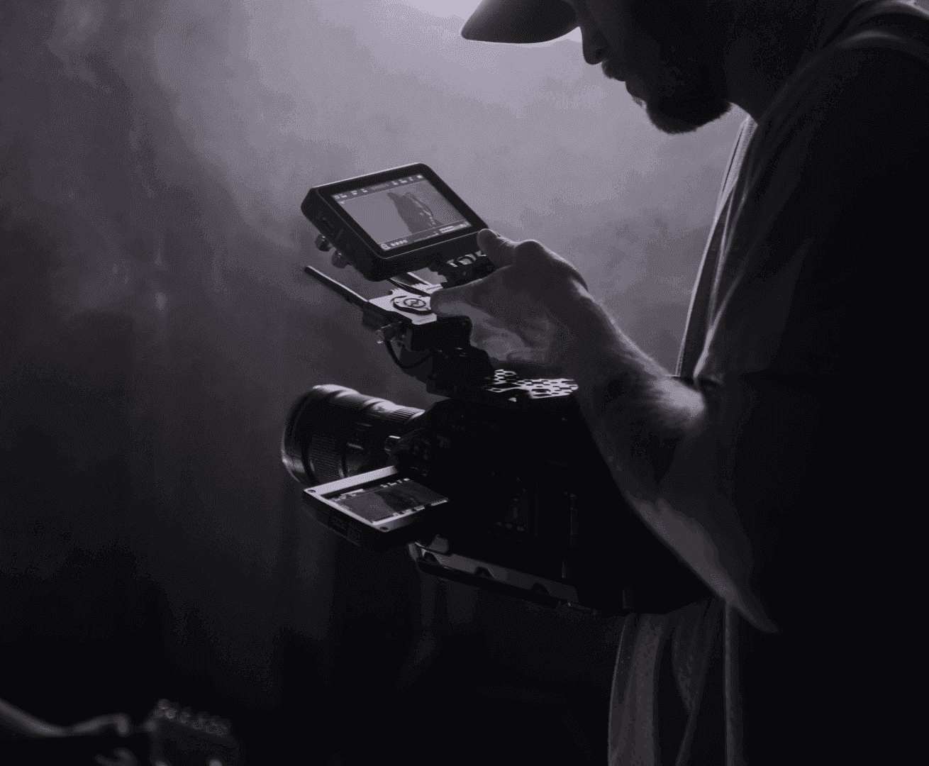 Corporate Event Video Production: A videographer holds a camera and looks at the video on the buiilt-in screen