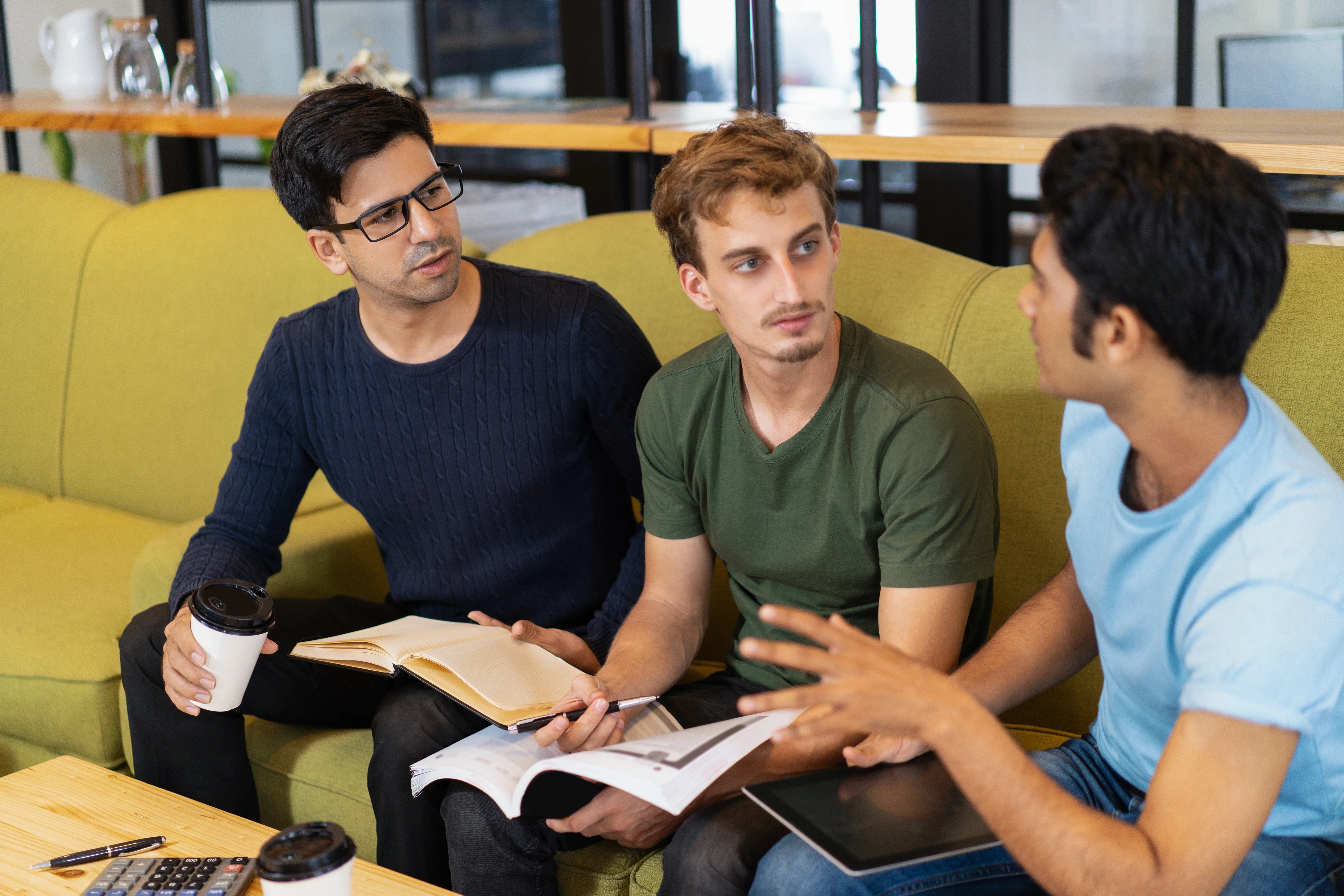 three-serious-fellow-students-discussing-homework