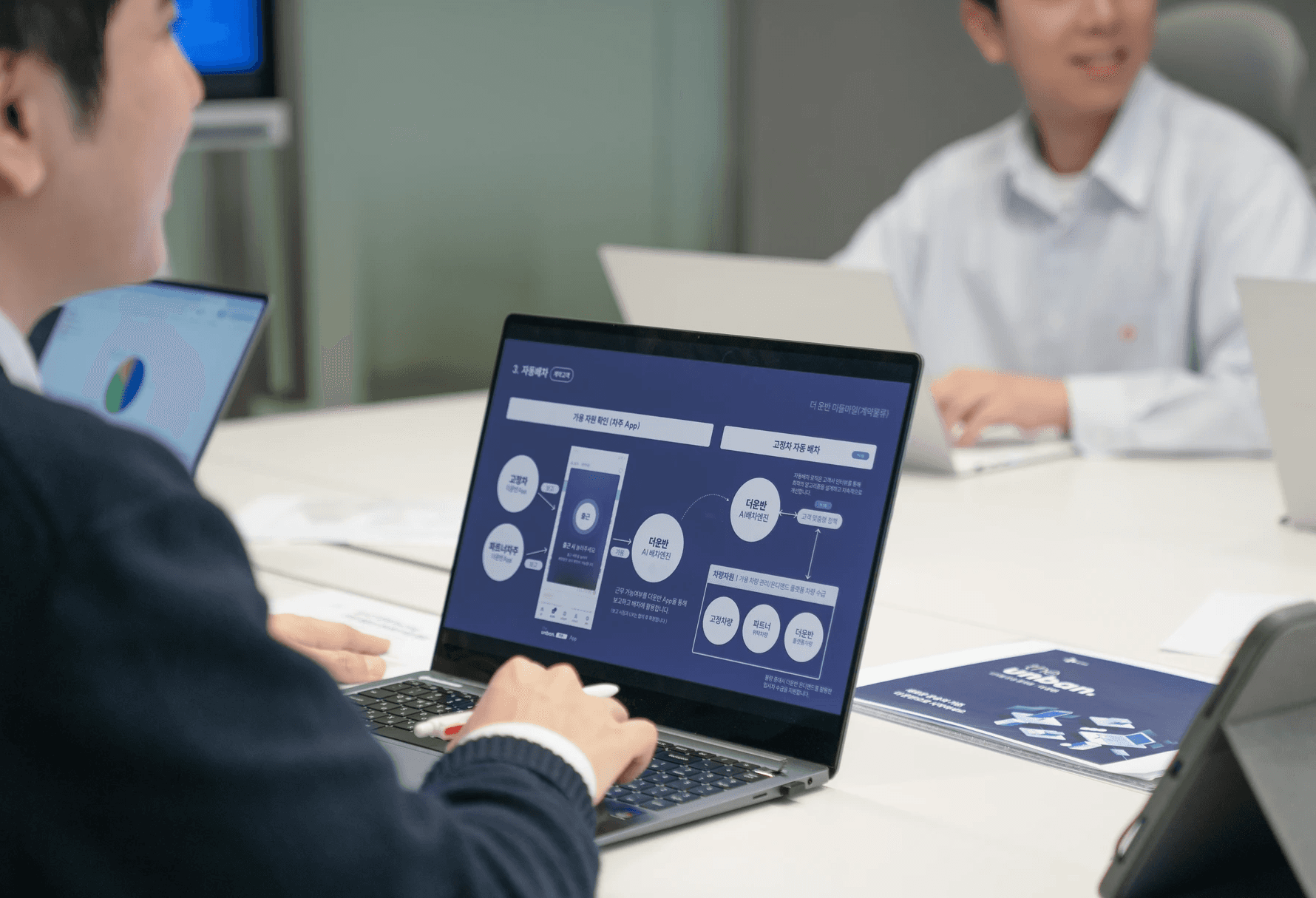 씨제이대한통운 더 운반 컨설팅 담당자가 노트북으로 운송 운임 구조 최적화 솔루션을 분석하고 있습니다.