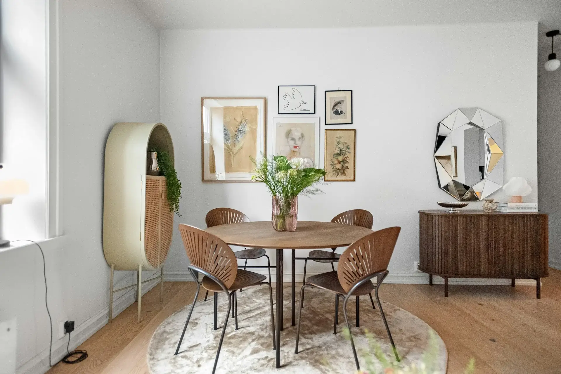 Bright modern living room with neutral sofa, glass coffee table, and abstract wall art.