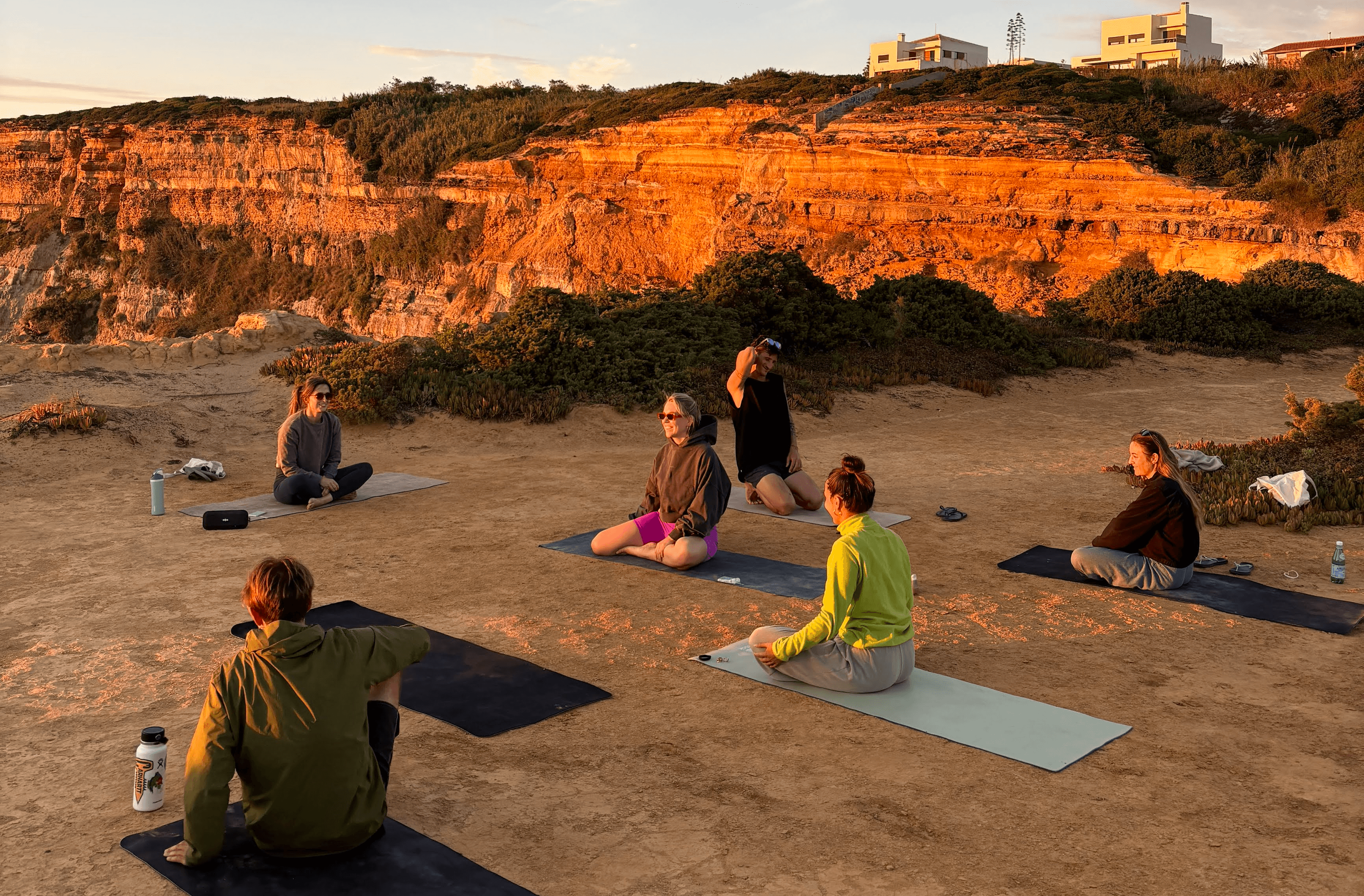 Wild Souls Coliving residents relaxing at a cliffside yoga class