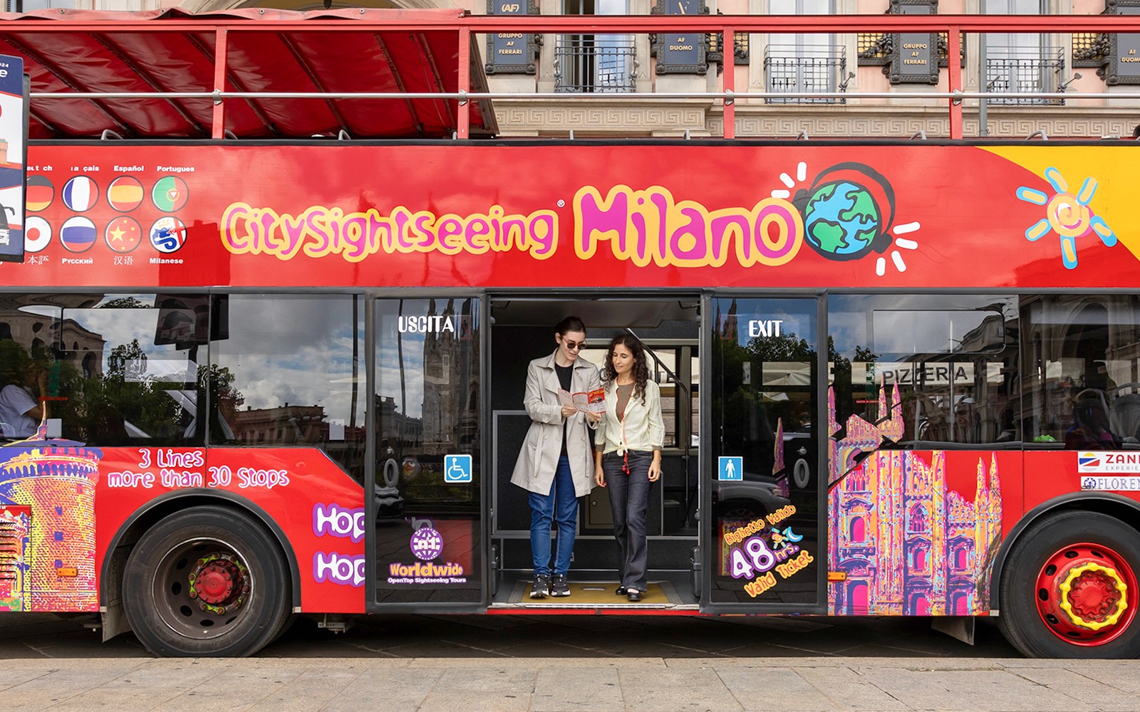Farþegar stíga út úr City Sightseeing hop-on hop-off rútu í Mílanó.