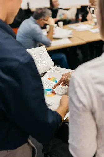 People working together at a table with paper and chalk.