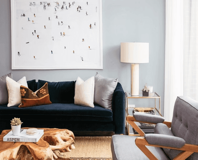 A person with short blonde hair holds a vintage camera.