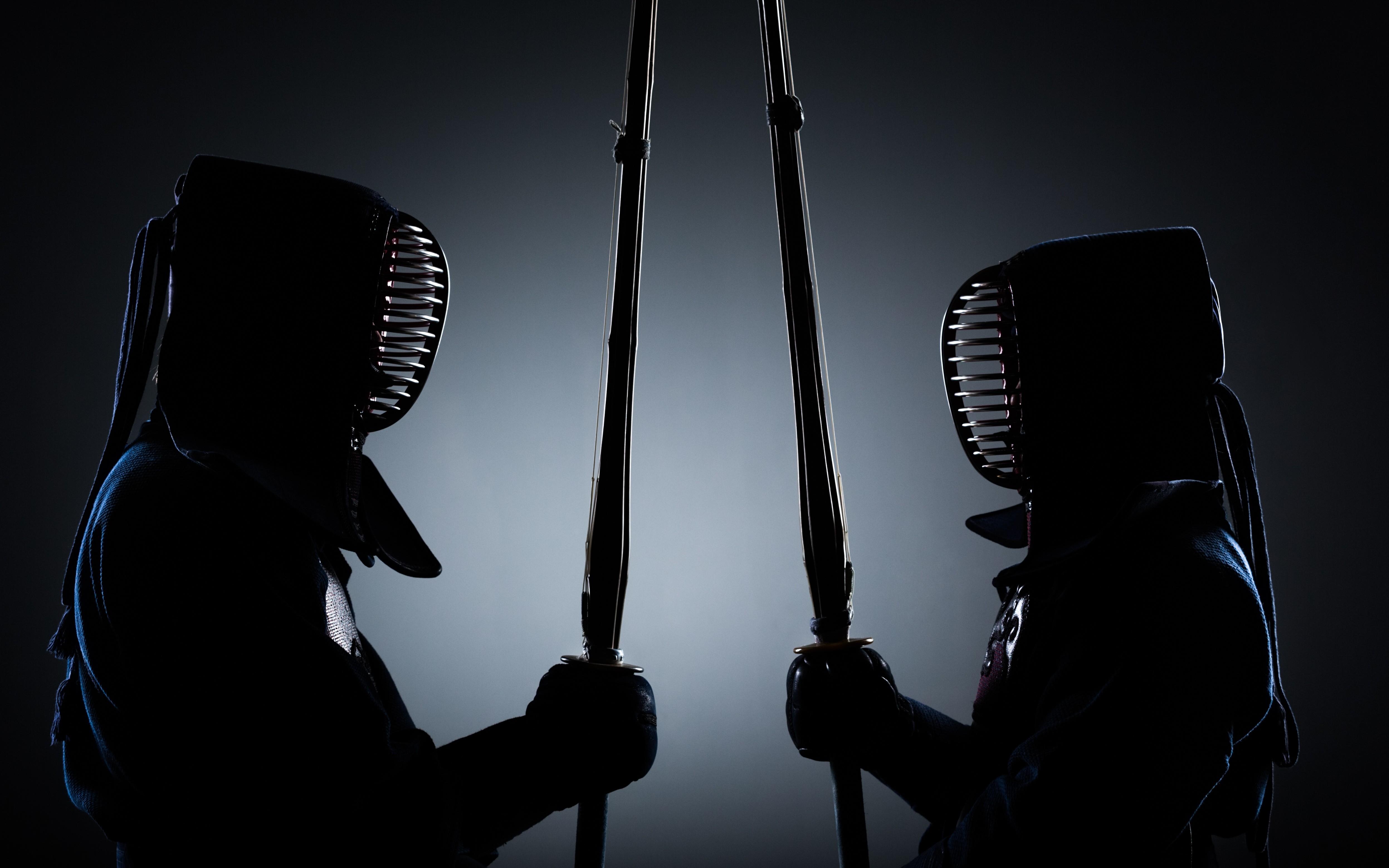 Deux pratiquants de Kendo en armure se faisant face dans un dojo.