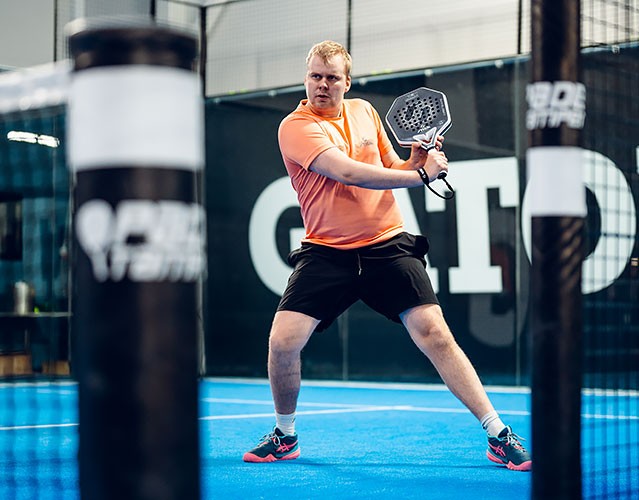 Antti Kampman pdel-kentällä lyömässä volleyta