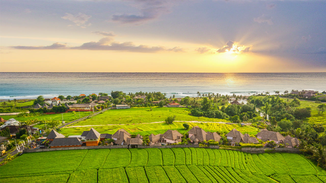 Stunning sunset over Pererenan rice fields; luxury real estate agency providing exclusive land and villa deals.
