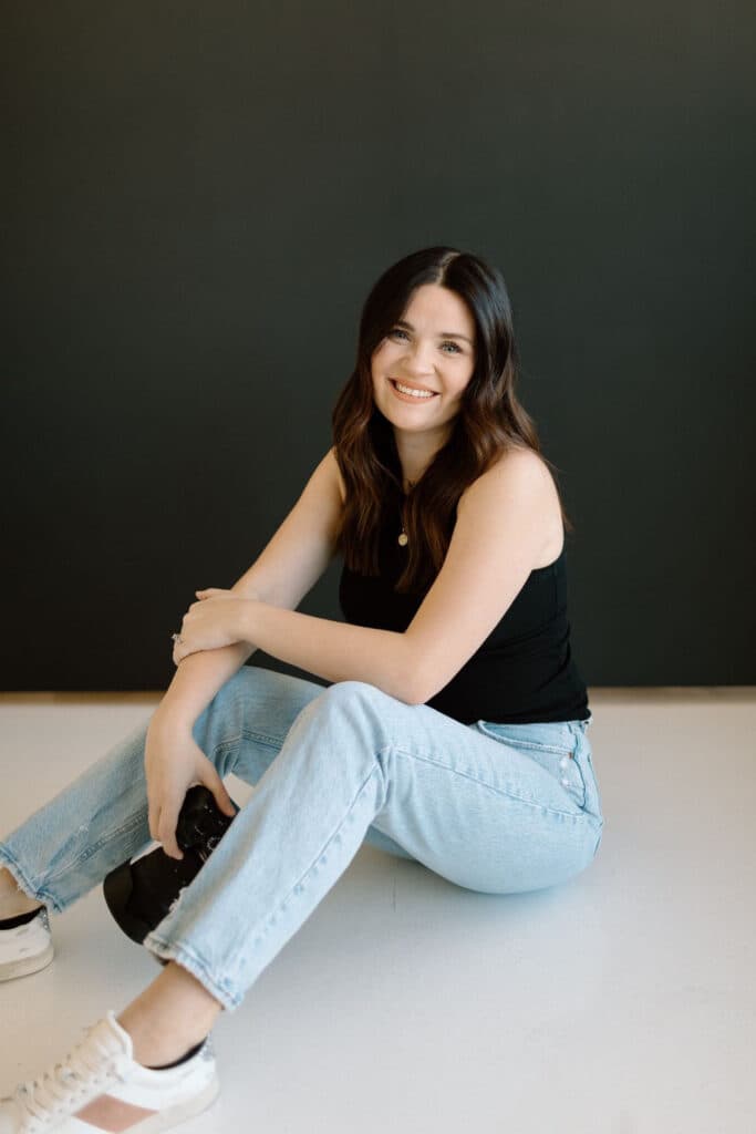 Breanna Kristine smiles while seated in the bright and modern Revelator Studio, a natural light photography studio in Shreveport, ideal for creatives and influencers looking for a versatile space.