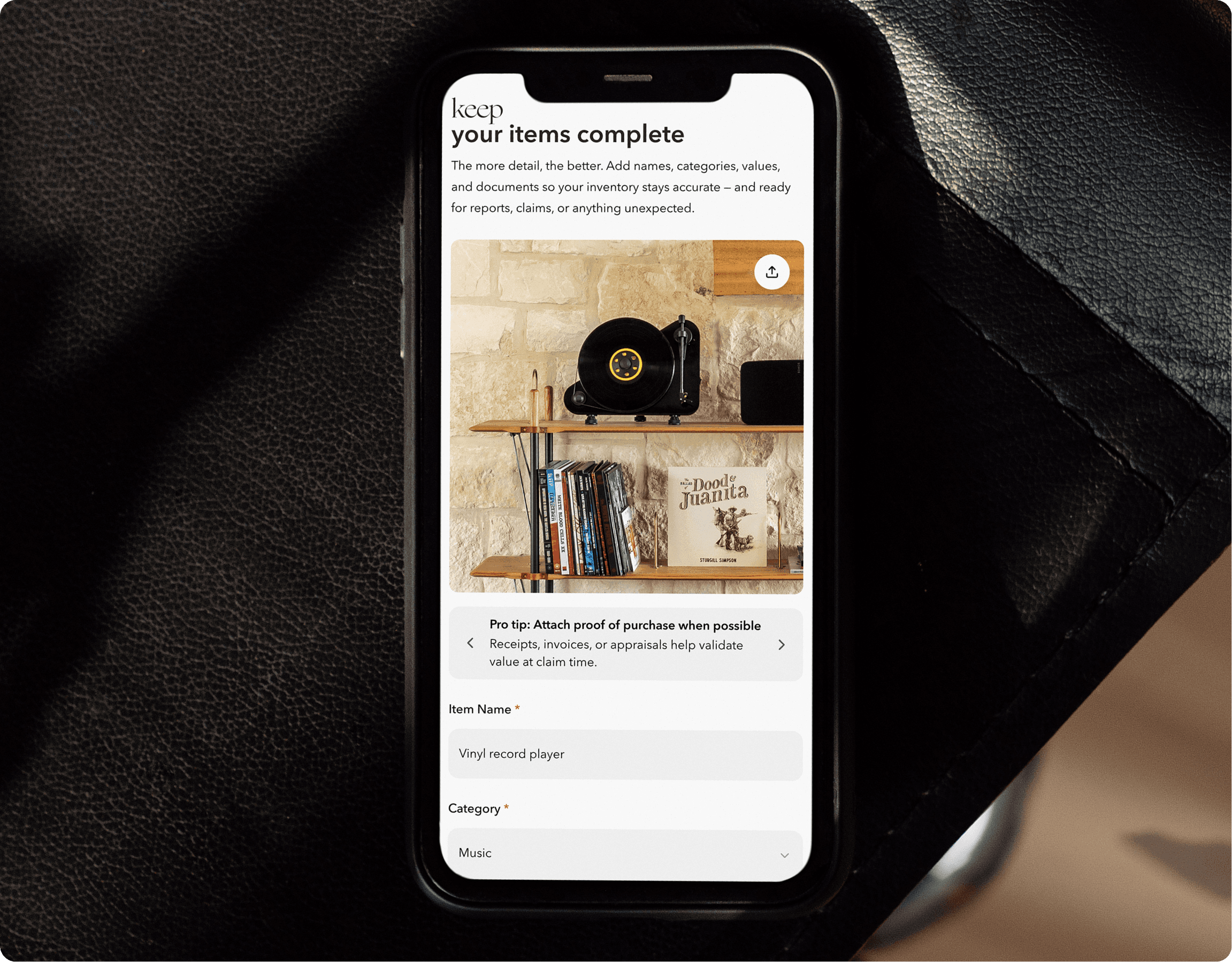 Hill country living room with cognac leather sofa, exposed wood beams, and open concept kitchen with sage green cabinets