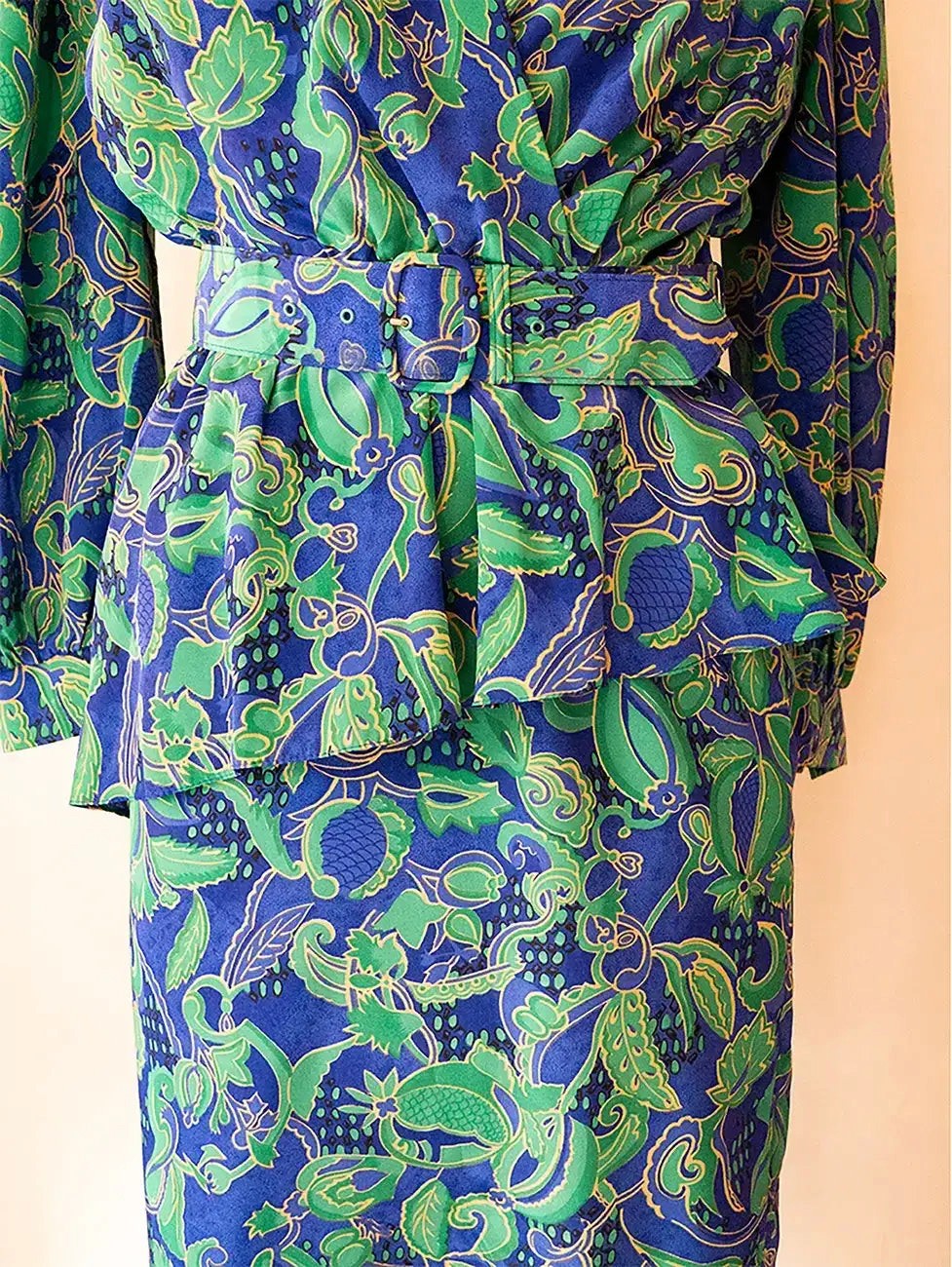 Vintage green and blue paisley print two-piece set with structured top and pencil skirt.