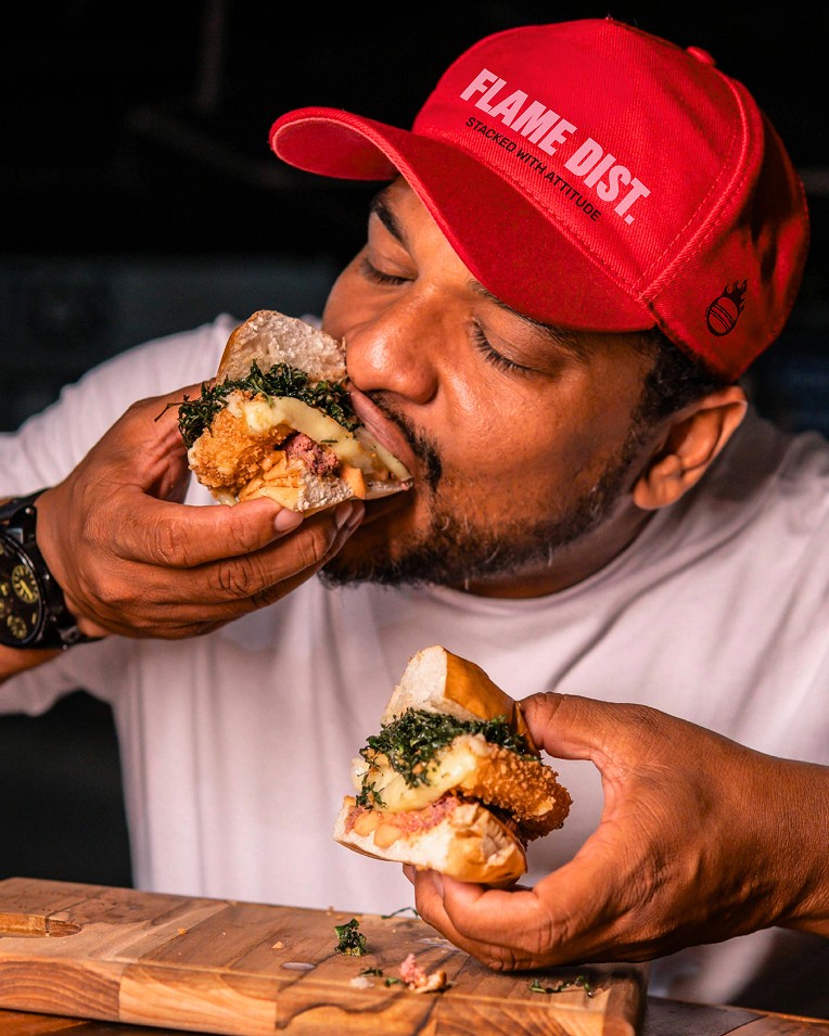 man eating flame district burger